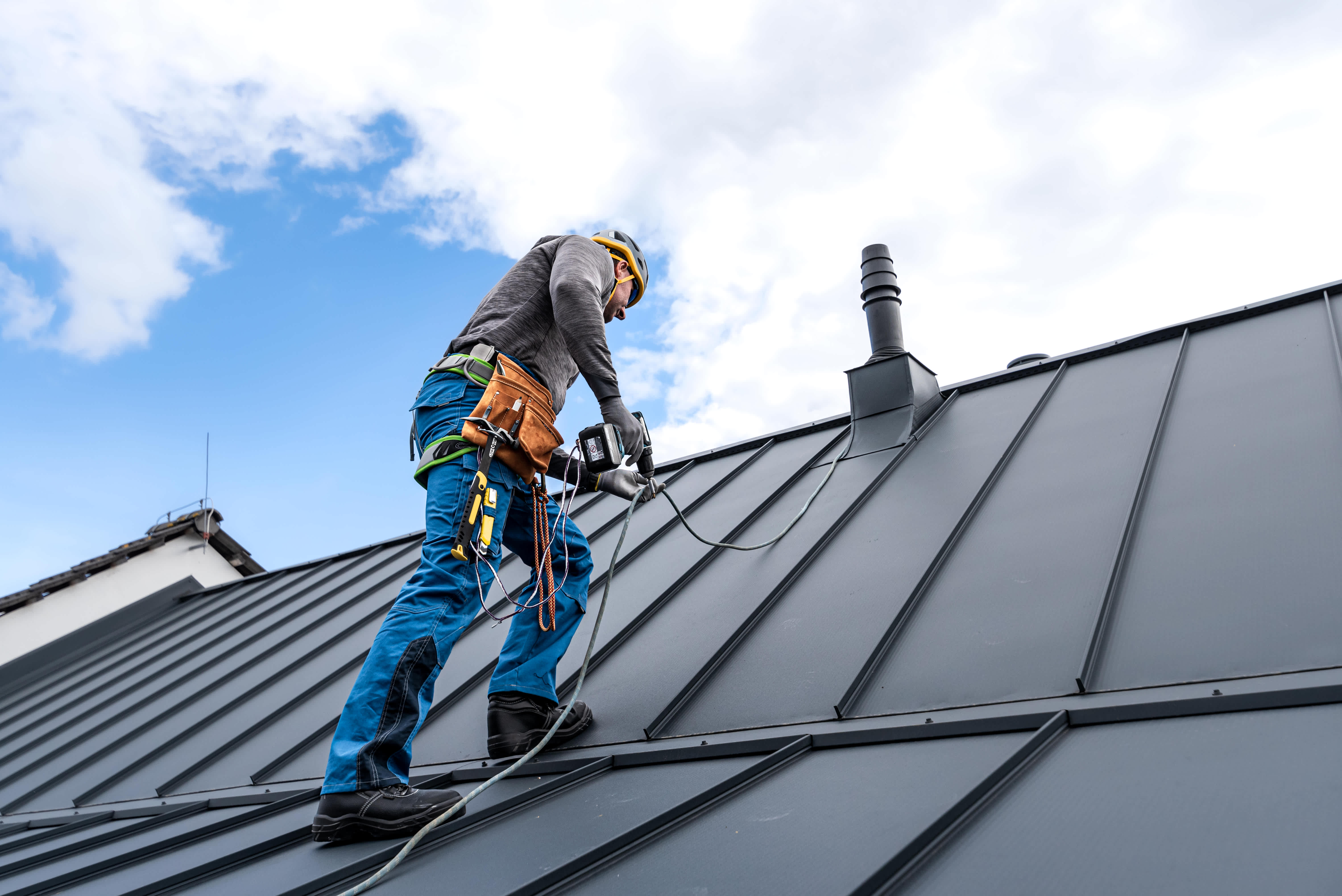 Roofer installing a standing seam metal roof