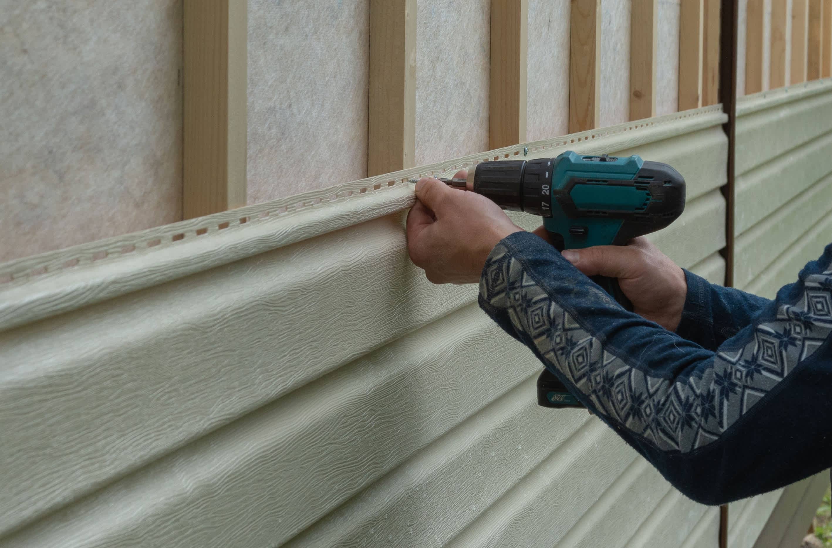 Worker installing siding panels