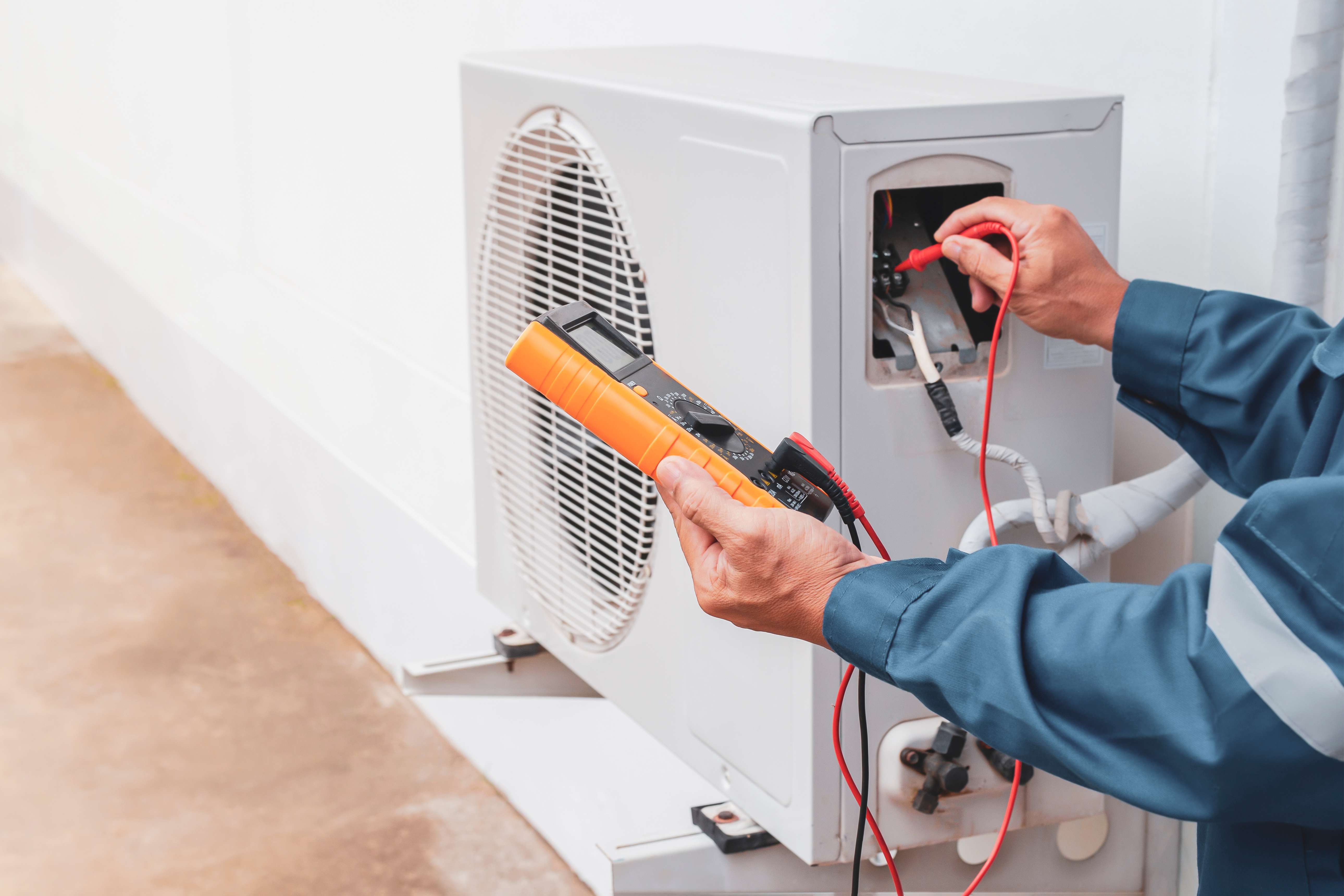 Technician repairing central air conditioning system