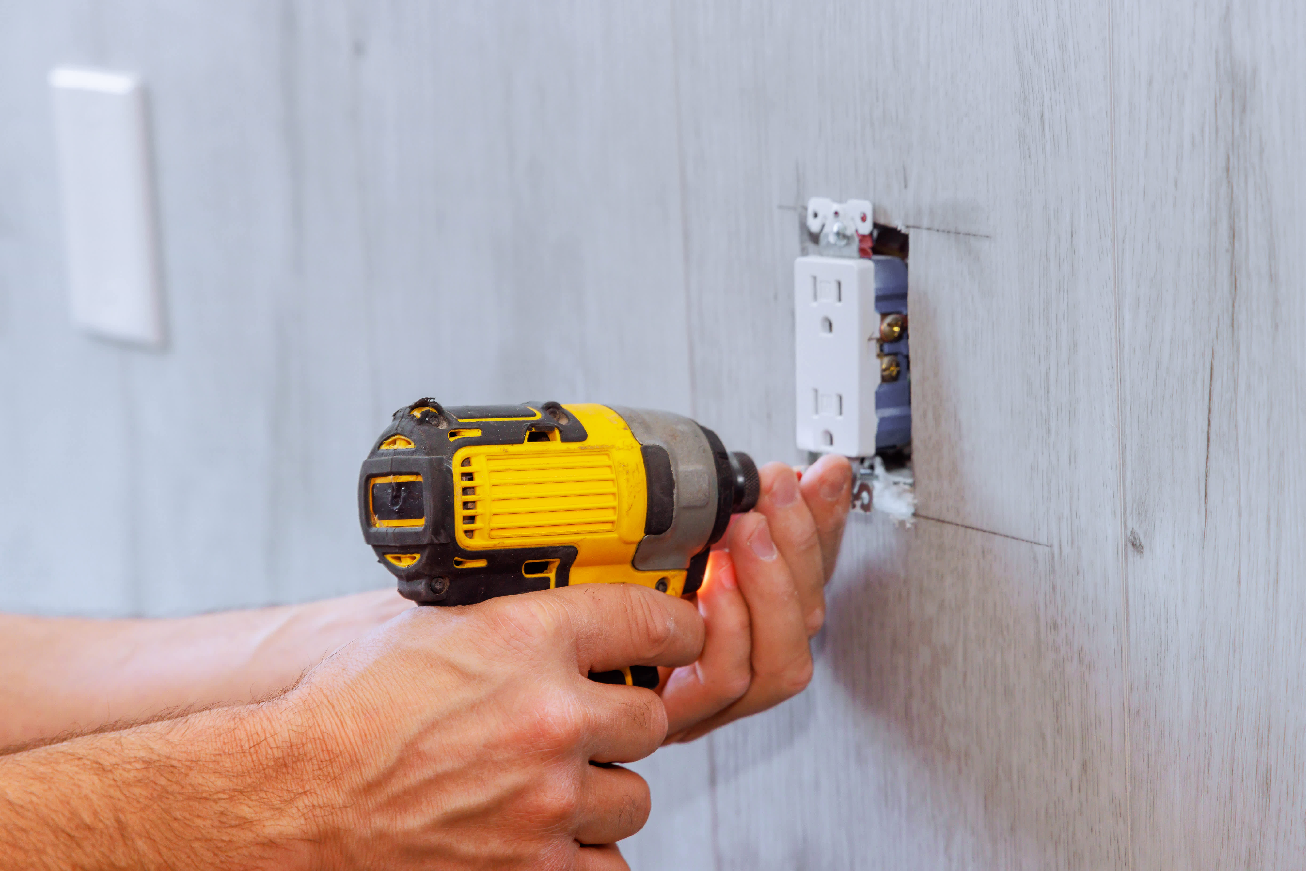 Electrician installing a new outlet in the kitchen