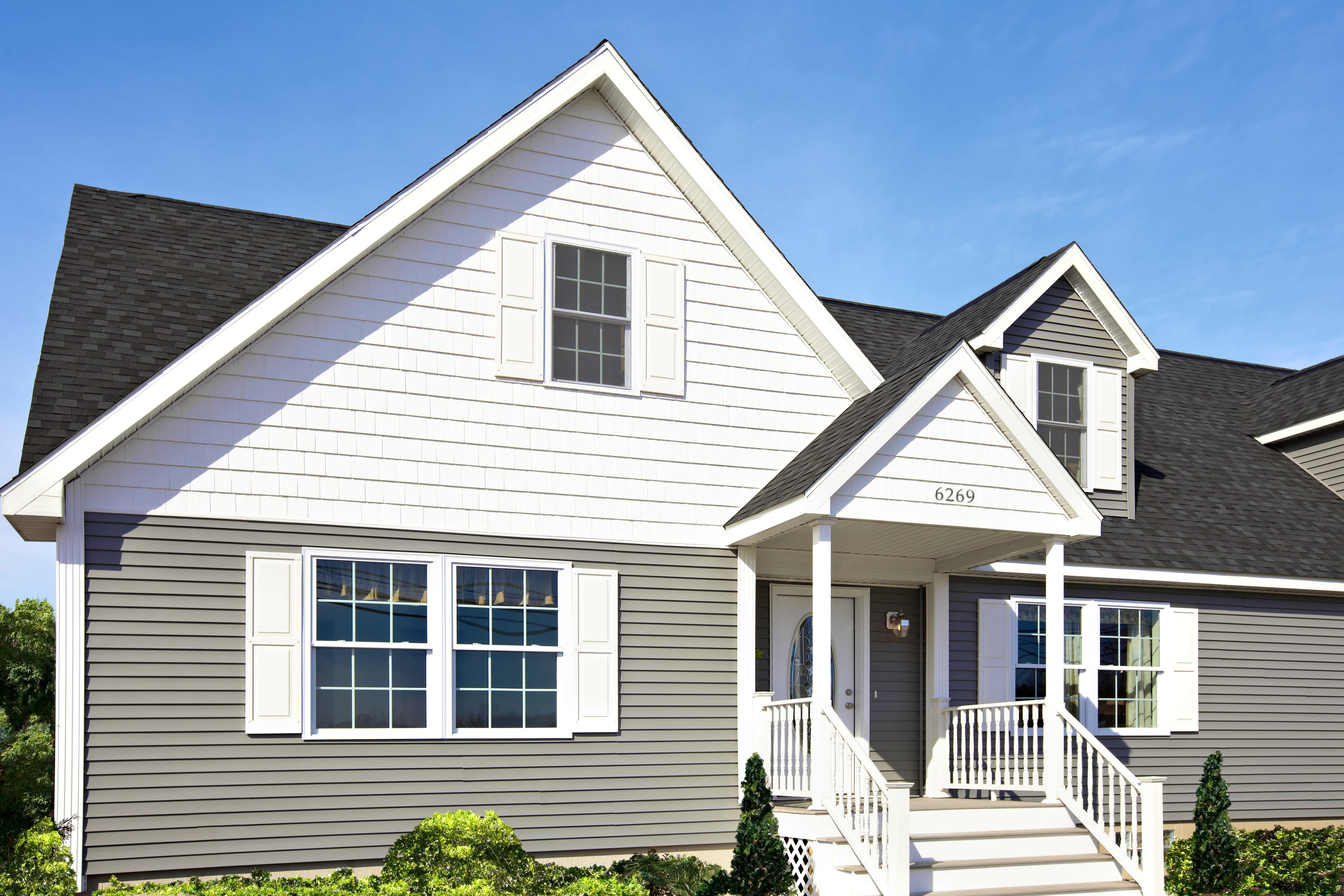House with gray and white fiber cement siding and window shutters