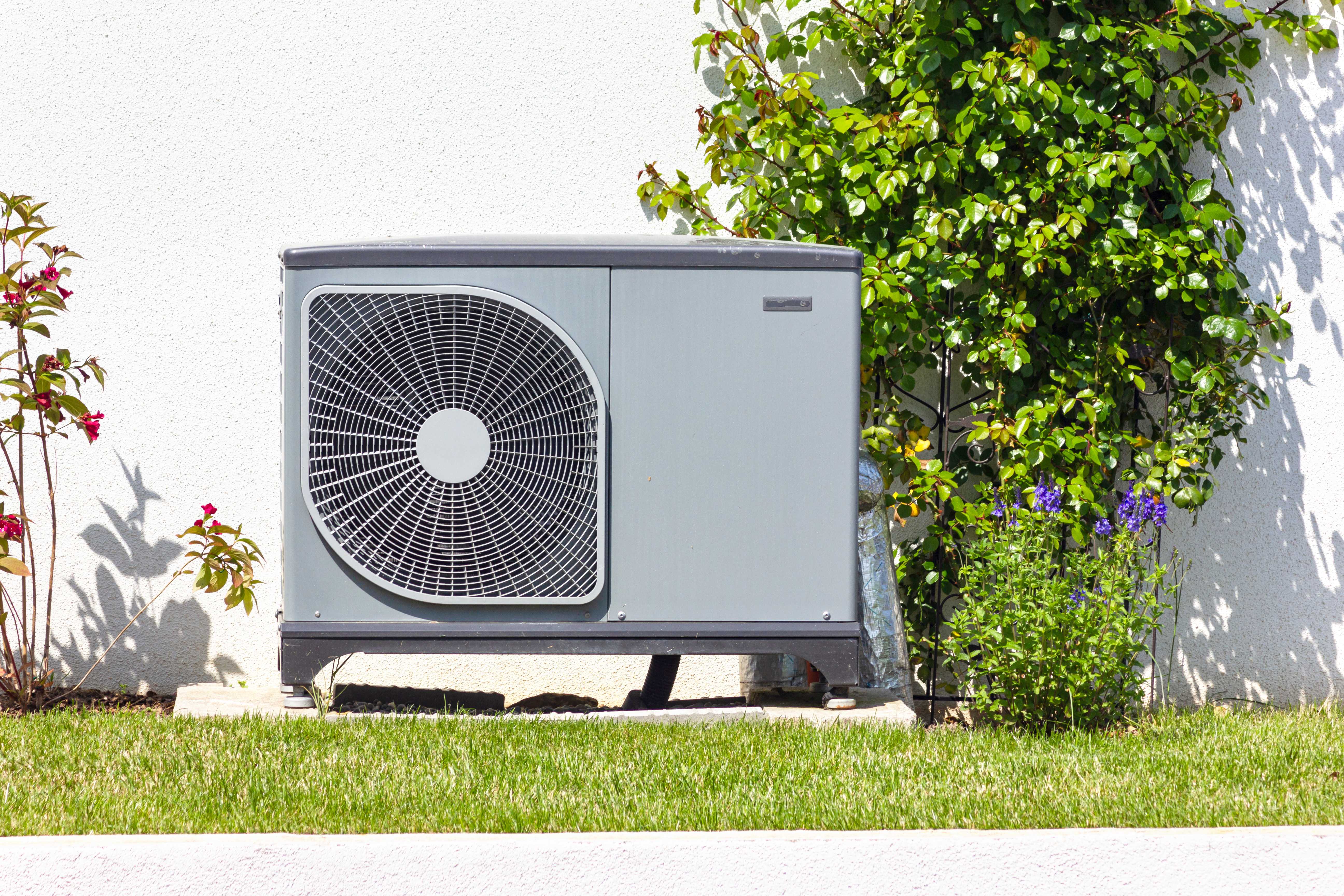 Heat pump sitting on a concrete slab in the yard
