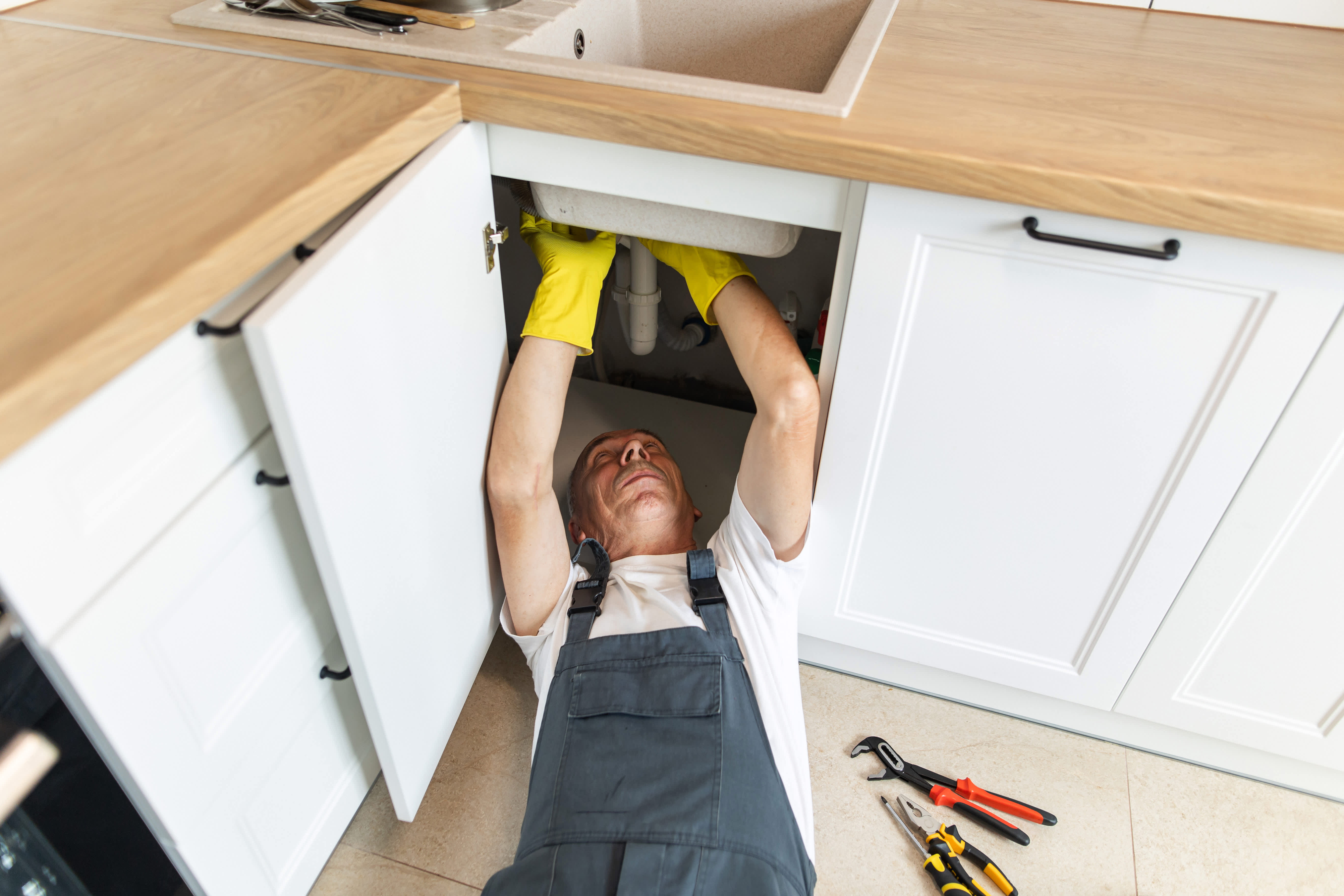 repairman working on bathroom sink