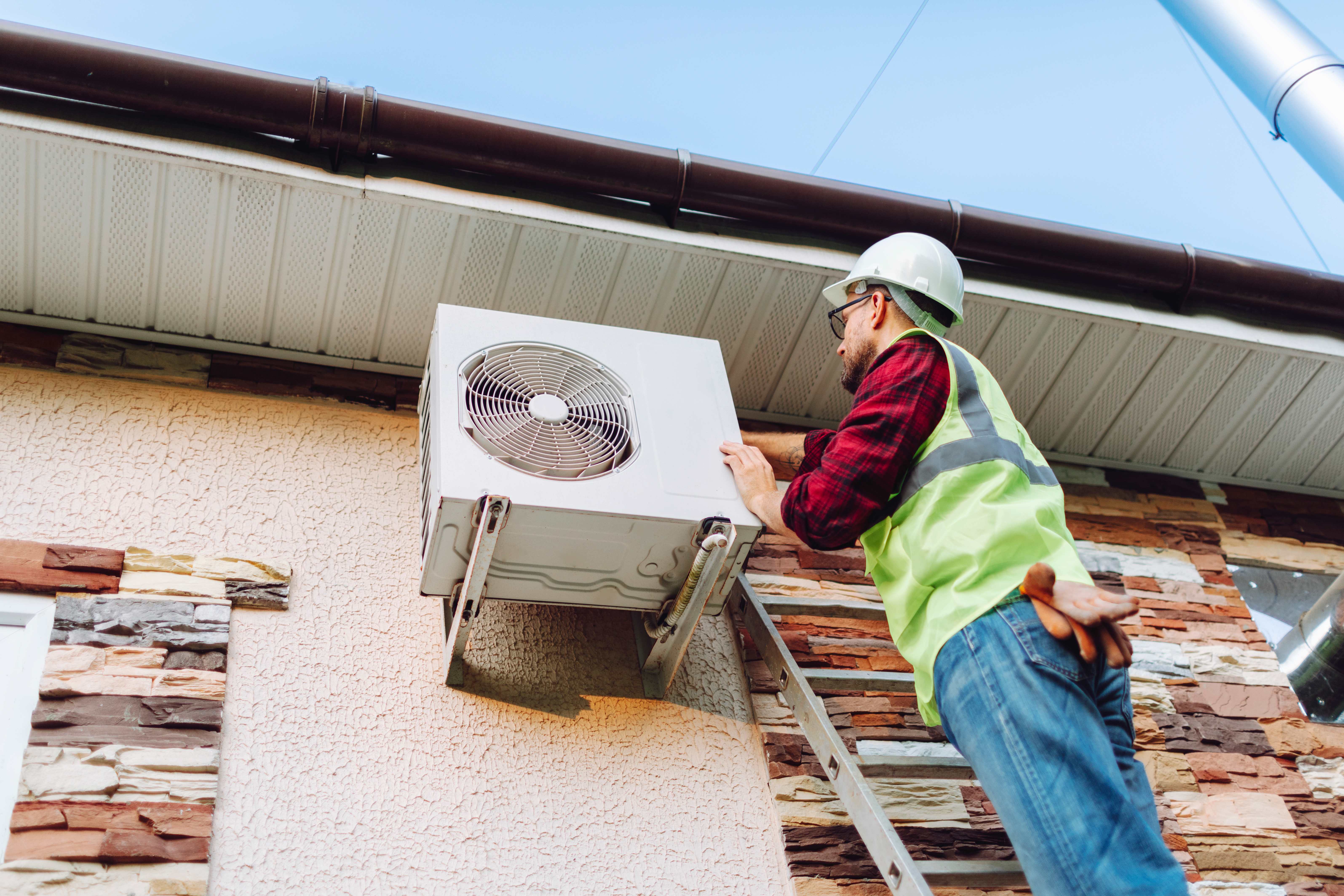 Technician repairing heat pump
