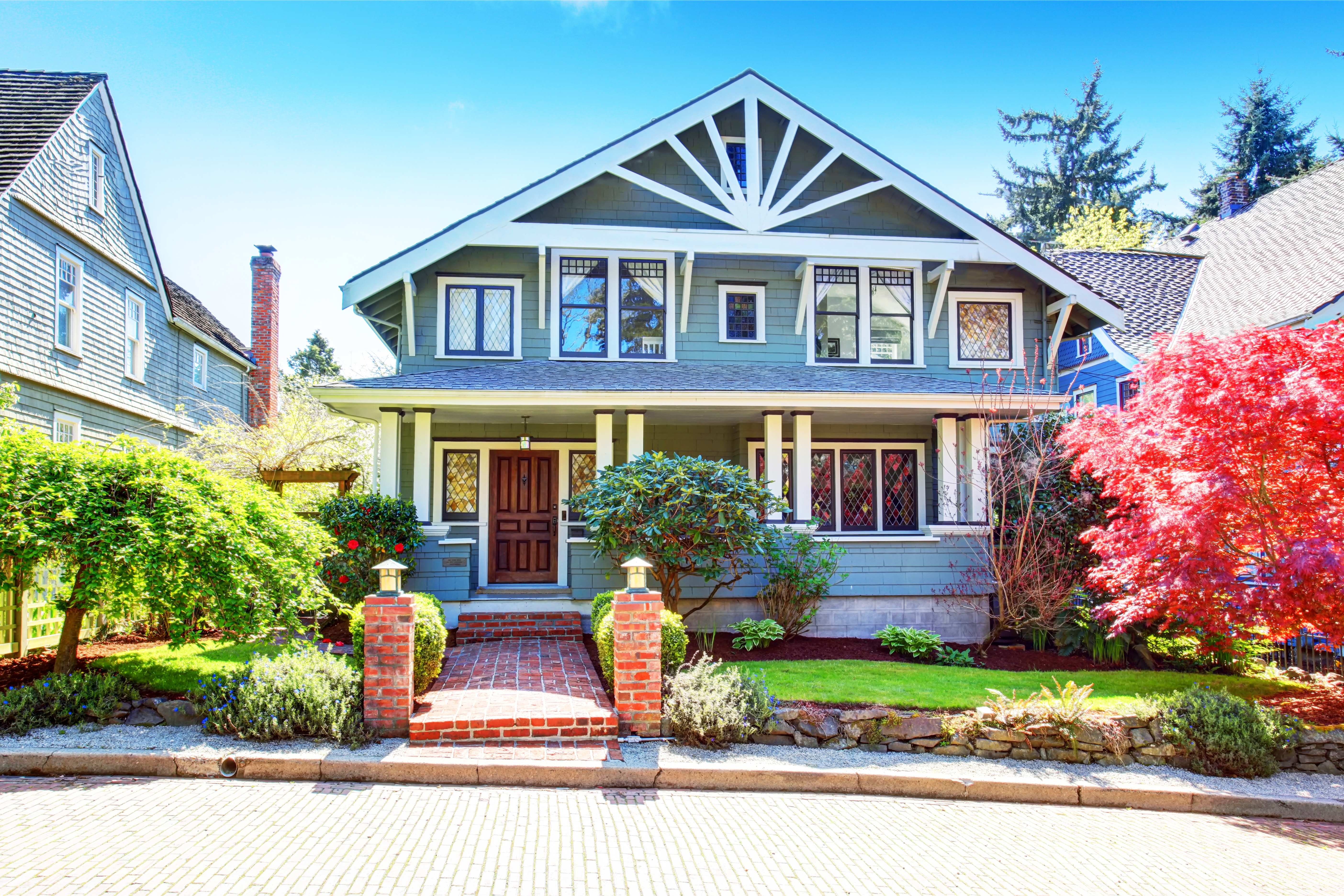 Craftsman style house with blue siding and a brick walkway
