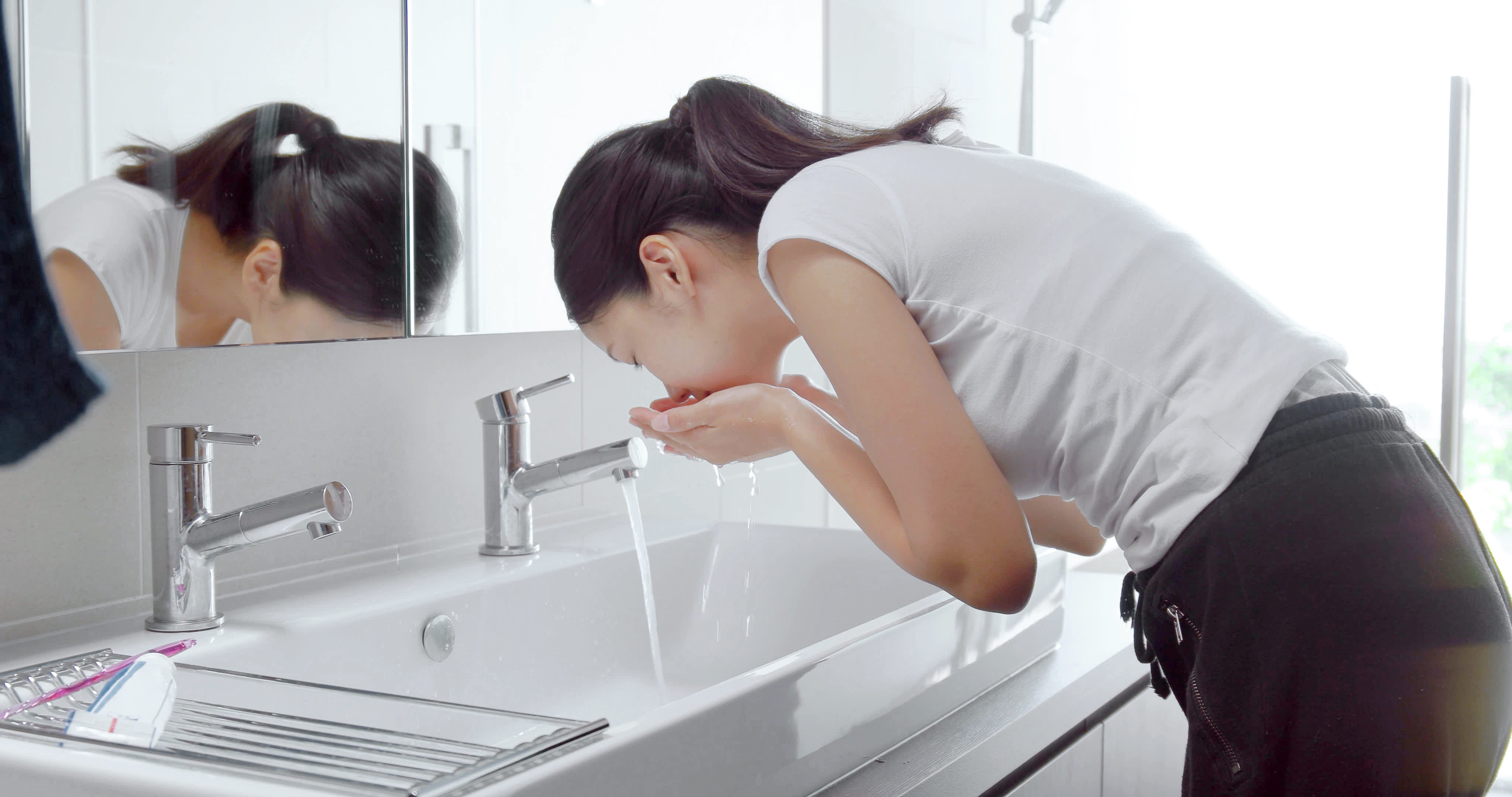 Woman in the bathroom brushing her teeth