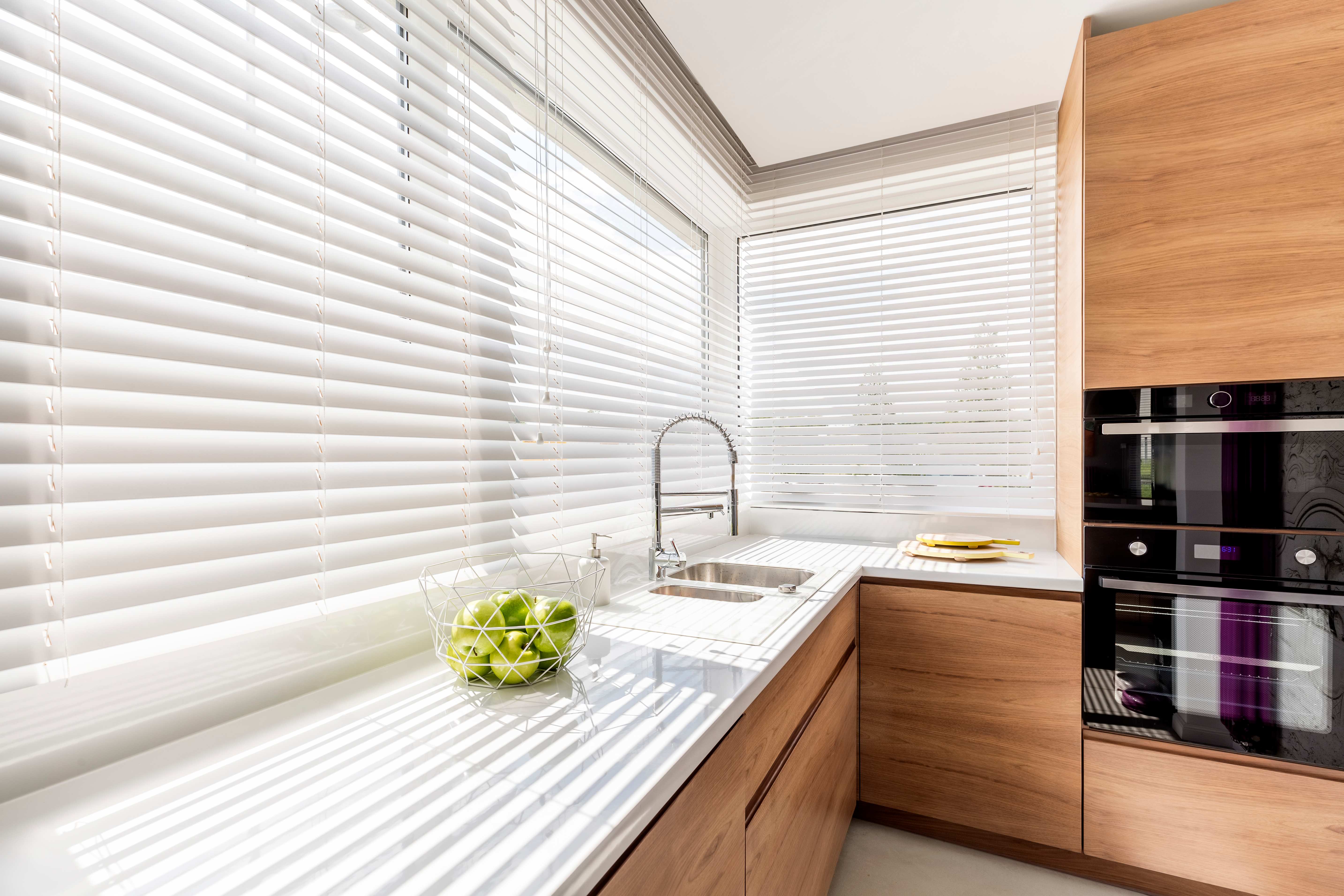 White mini blinds installed in a minimalist kitchen