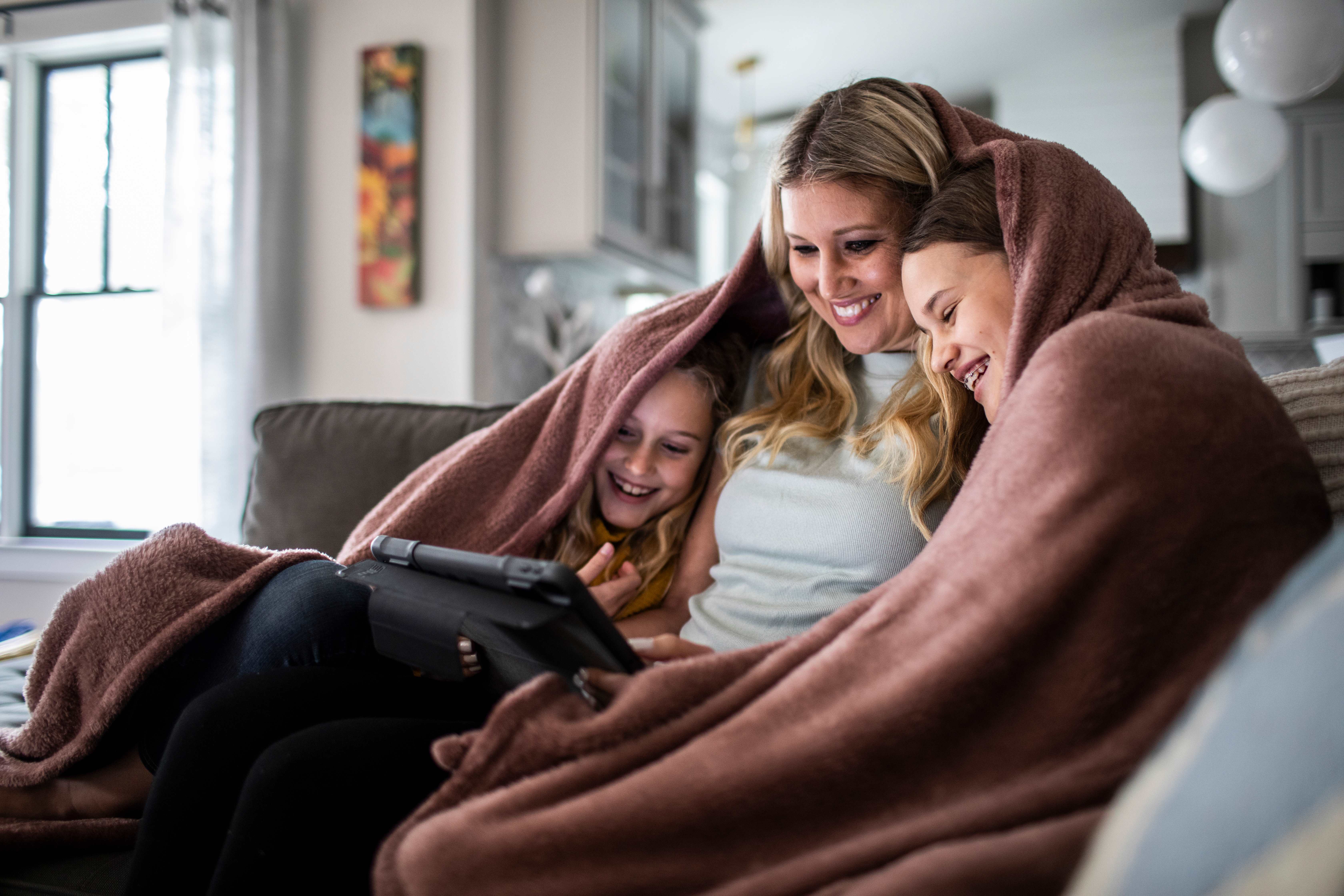 mom and children cozy under a blanket