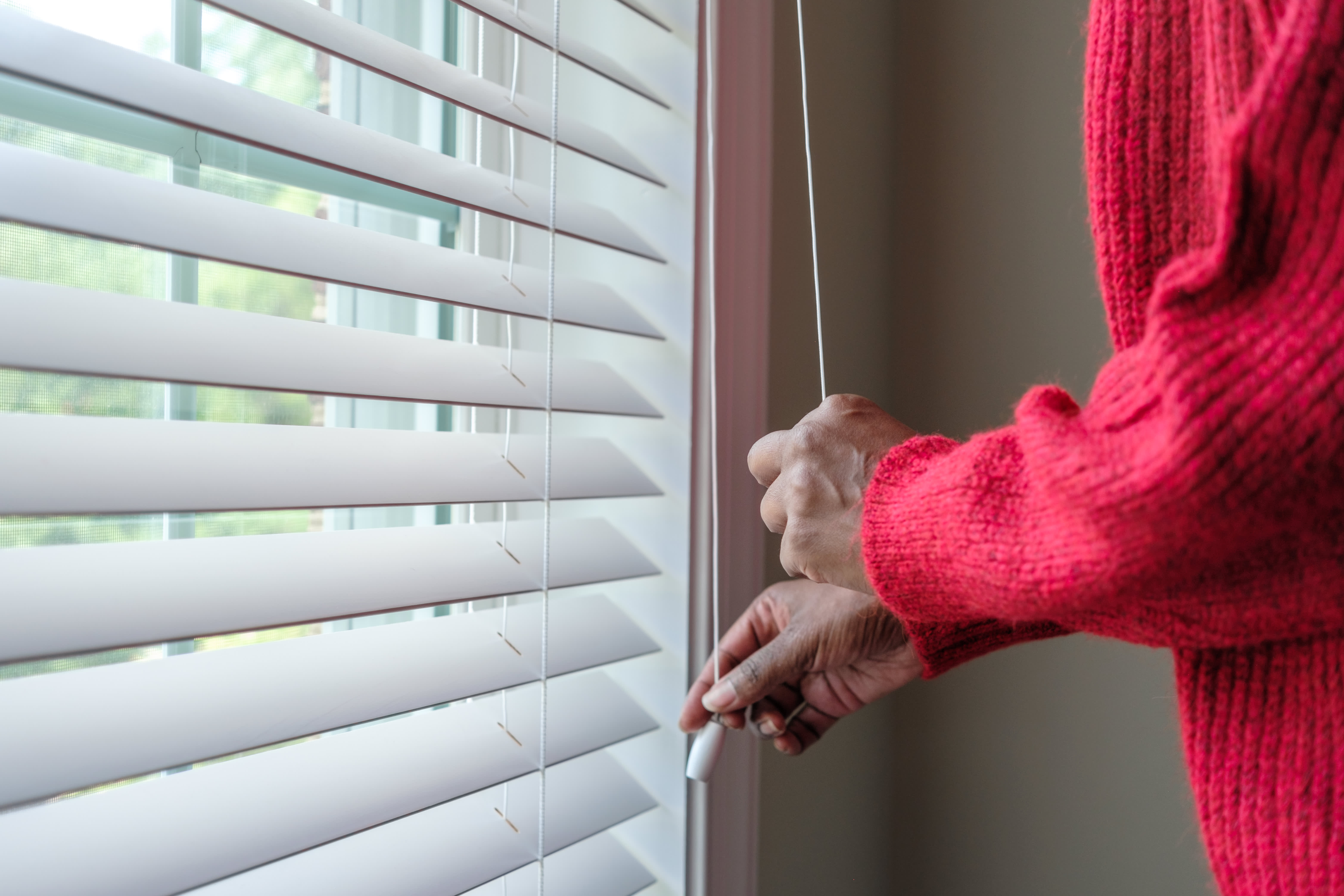 Woman opening window in living room
