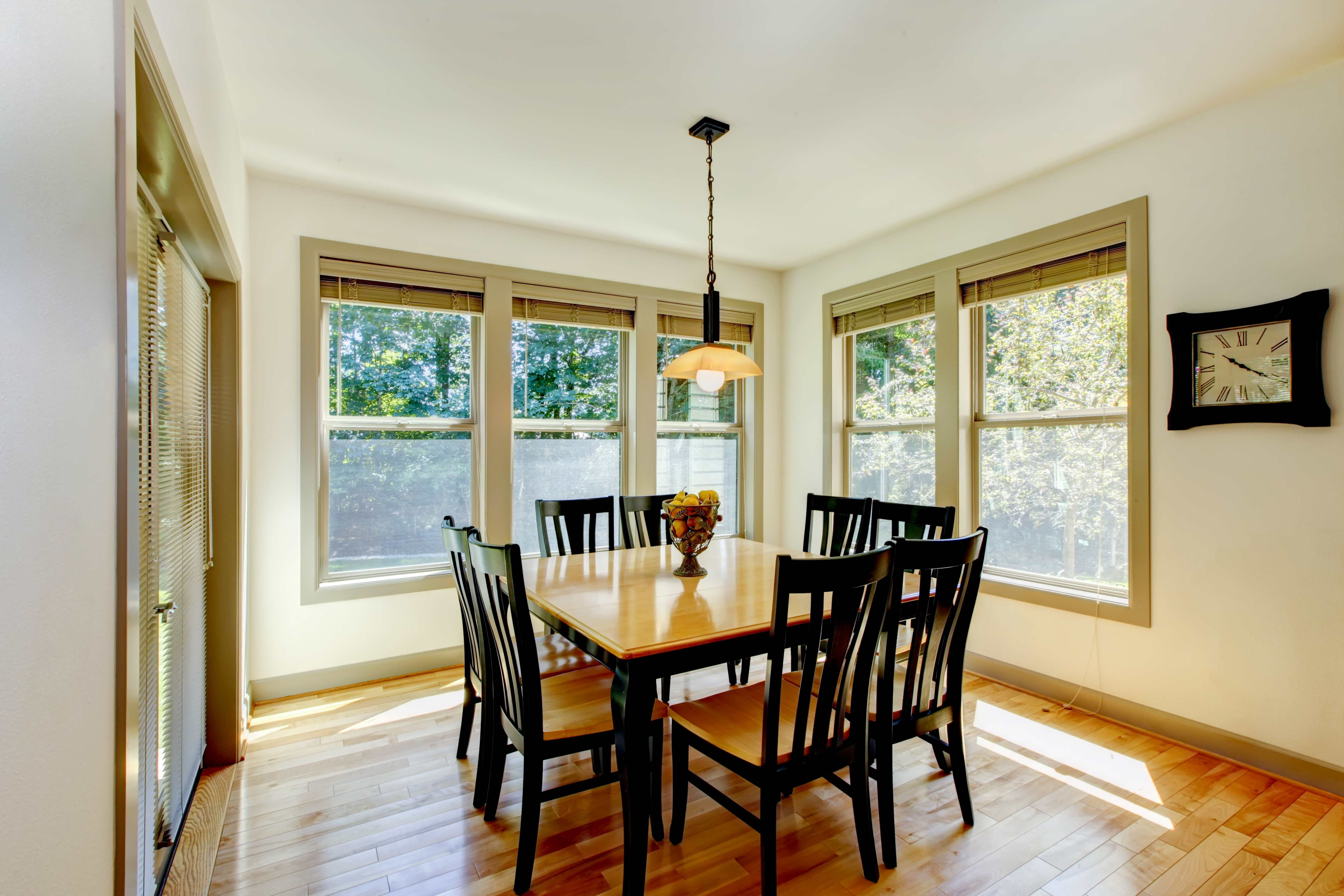 Double hung windows installed in a dining room with wooden flooring