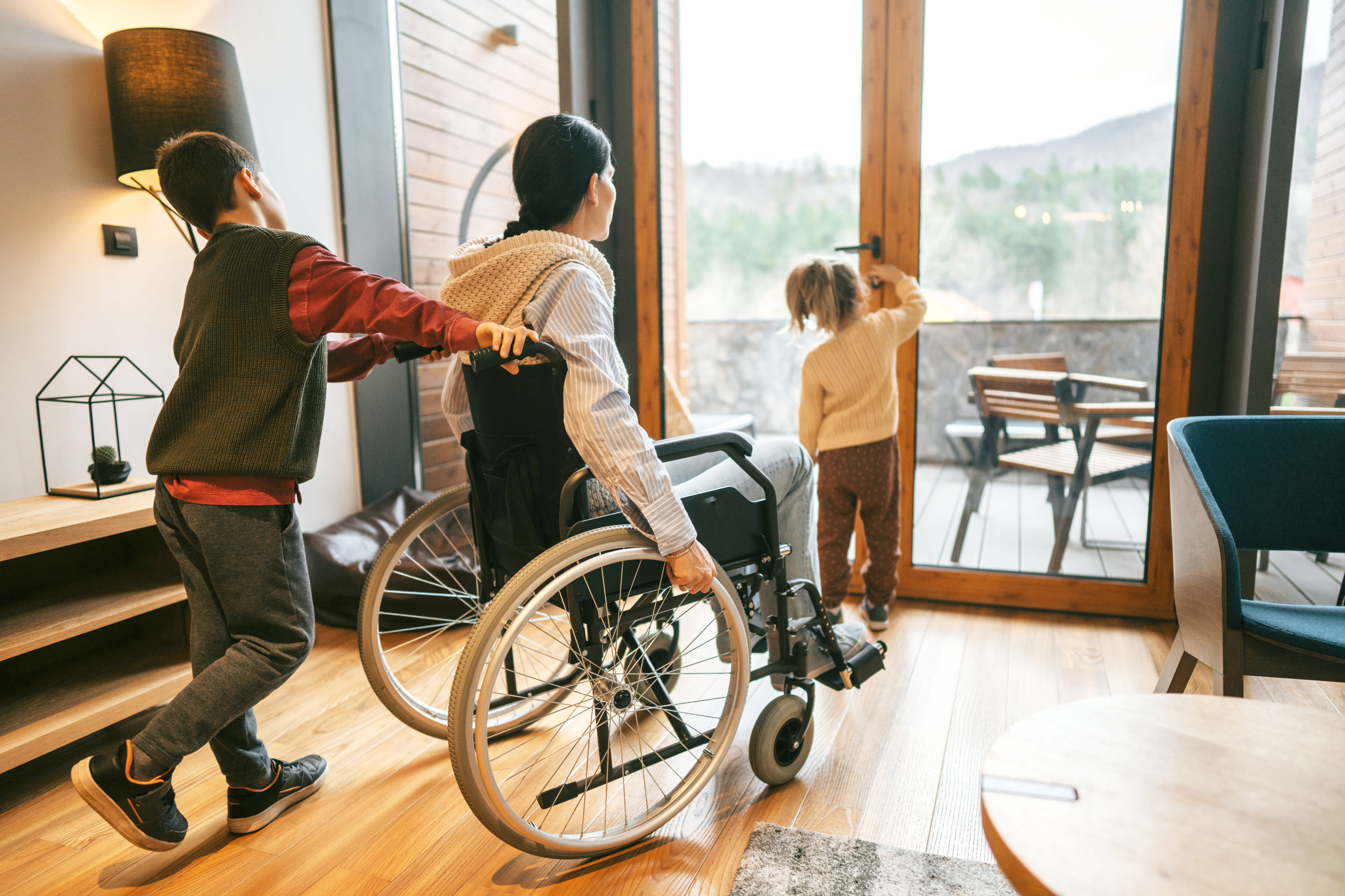 Woman in a wheelchair and kids going to the patio