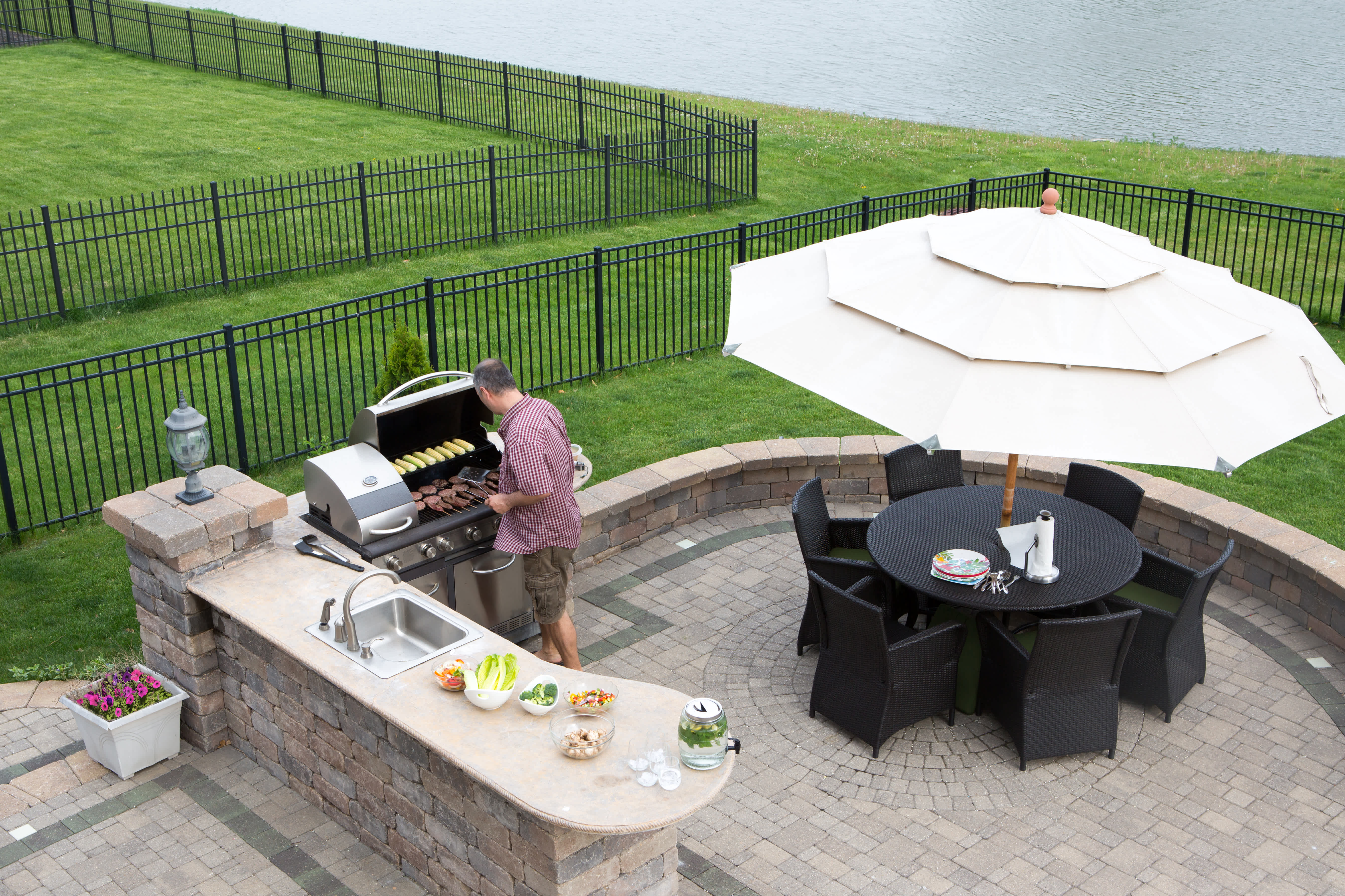 Man grilling burgers and enjoying his outdoor kitchen