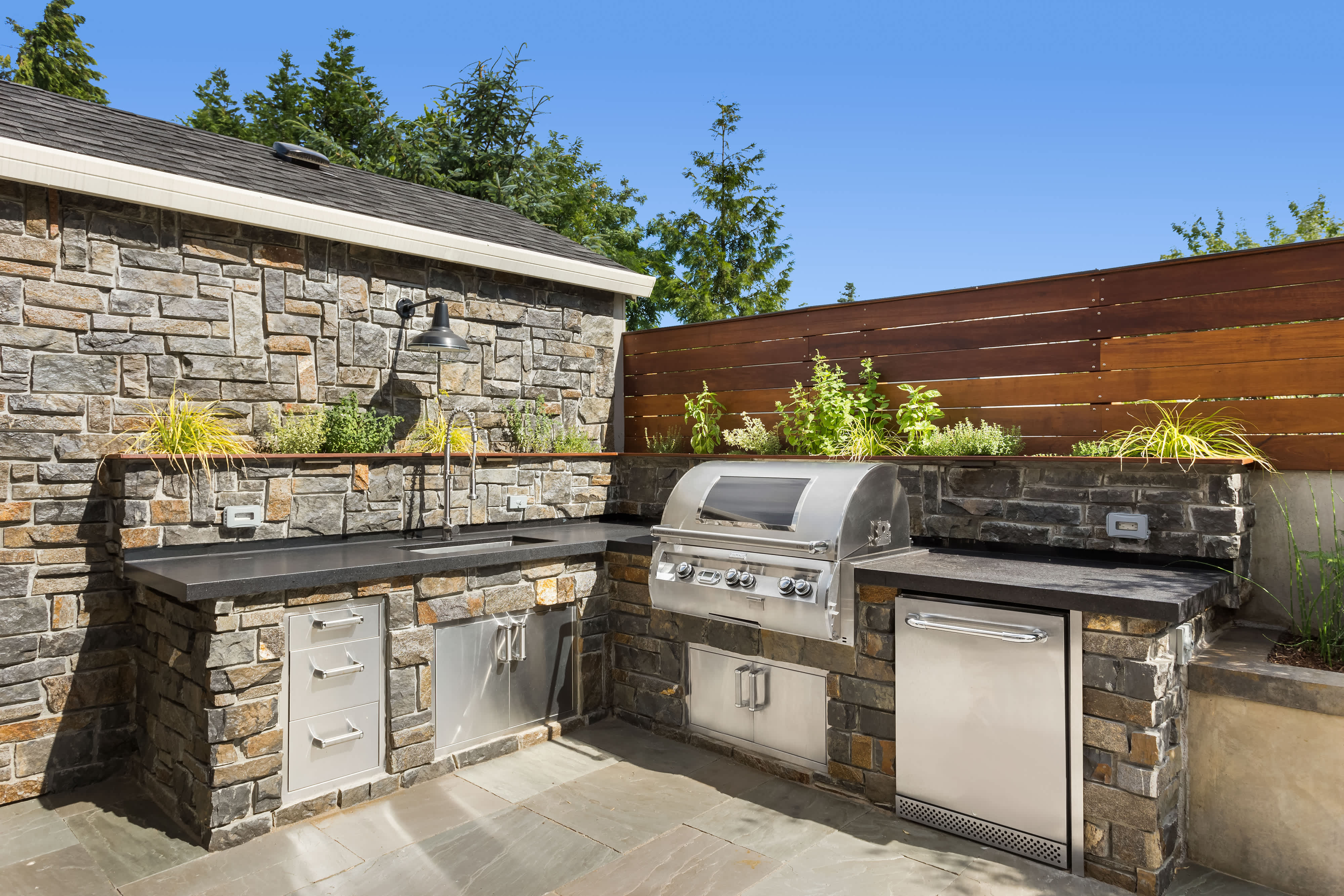 Outdoor kitchen with stainless steel sink and BBQ grill