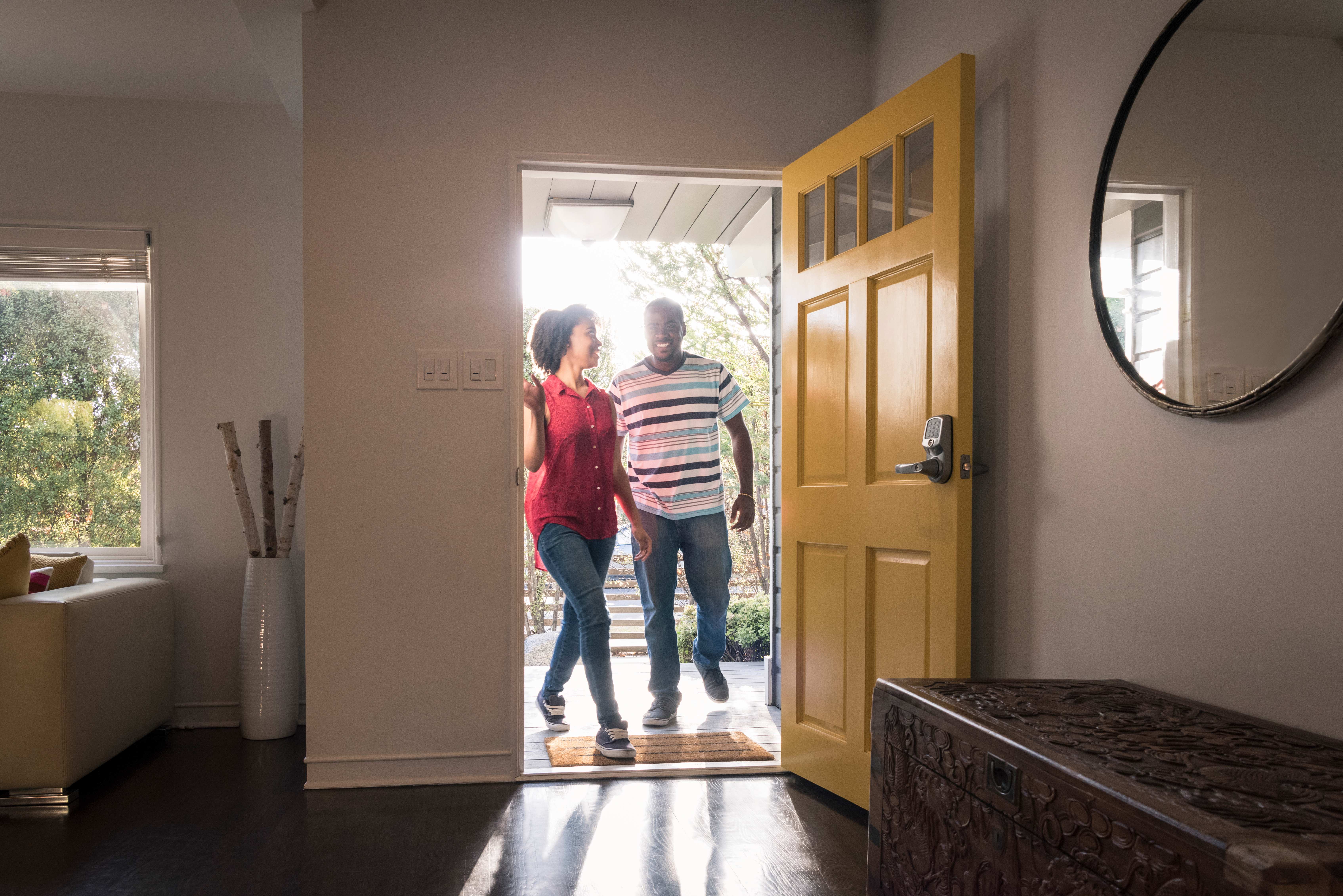 Young man and woman stepping into the house