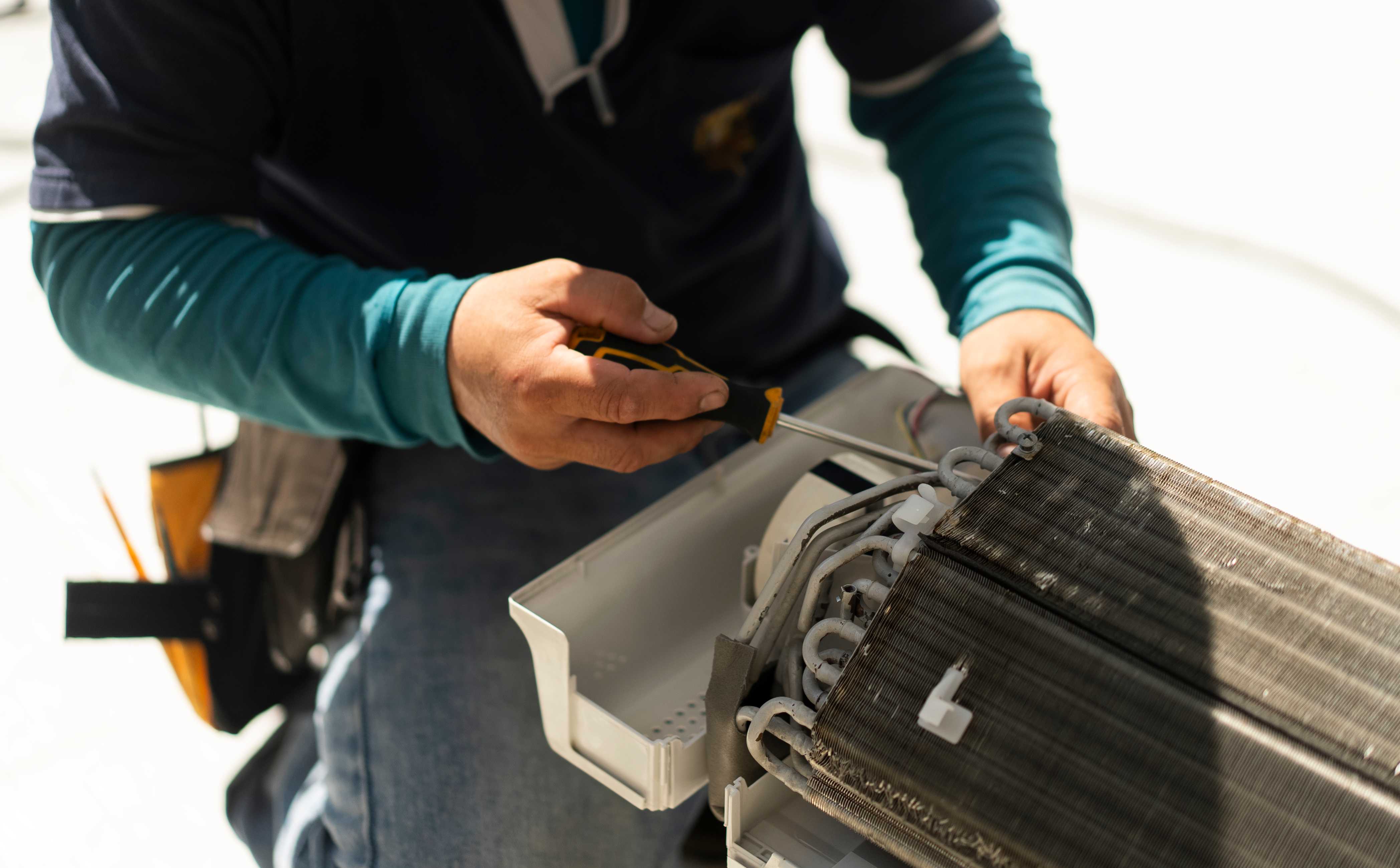 man repairing ac coil