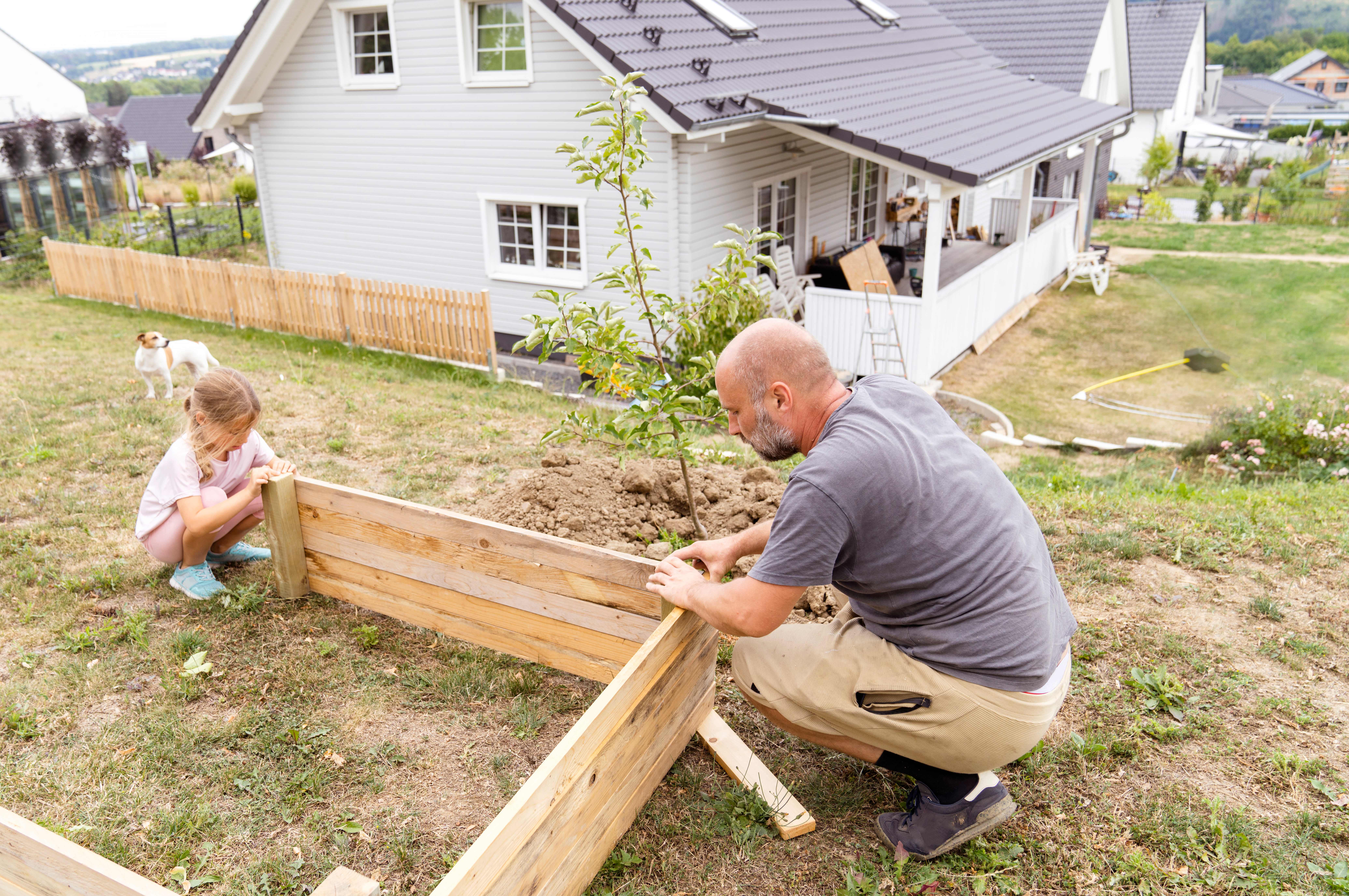 Father and daughter making a raised garden bed