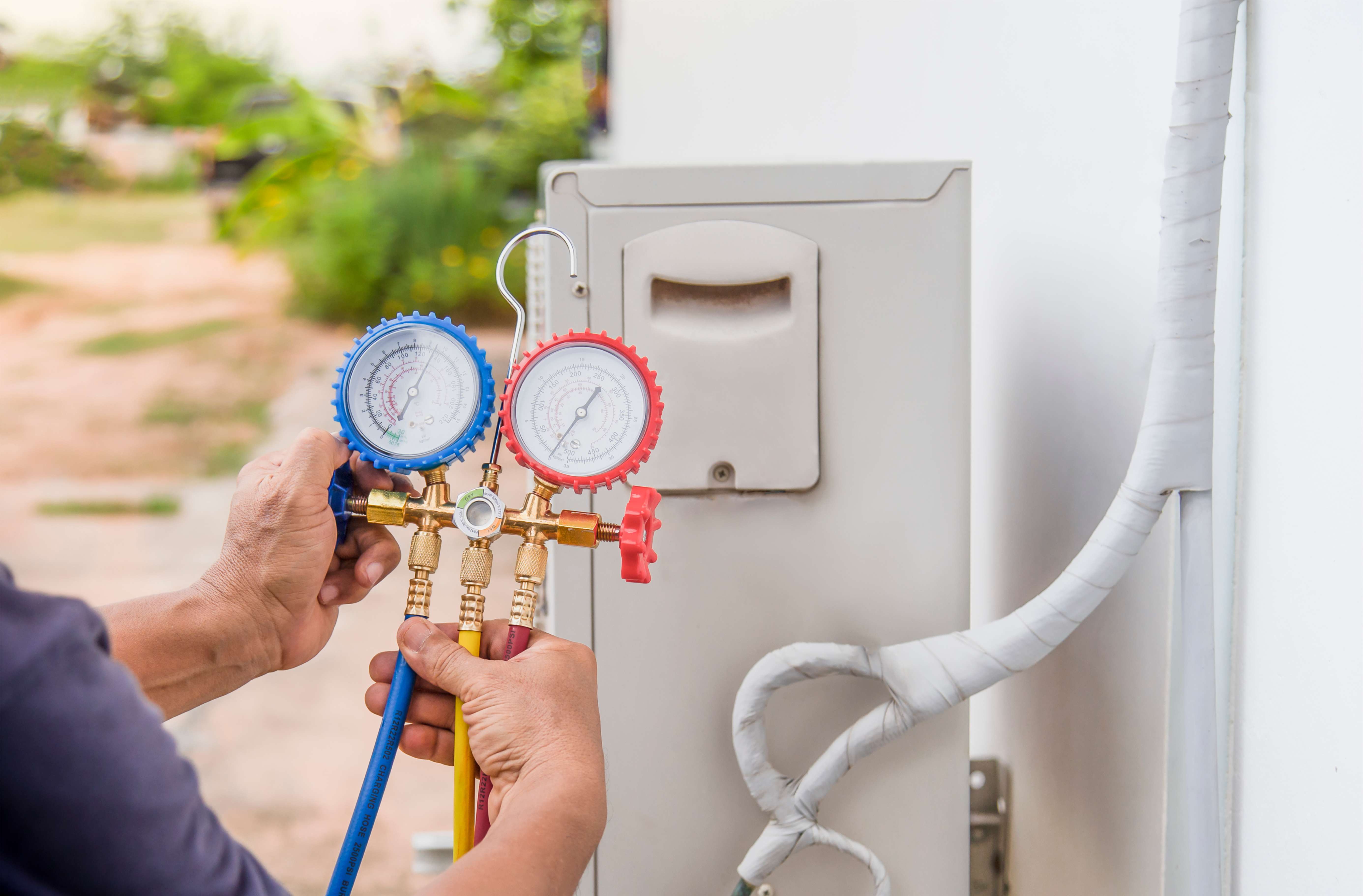 AC repair pro checking air conditioner refrigerant