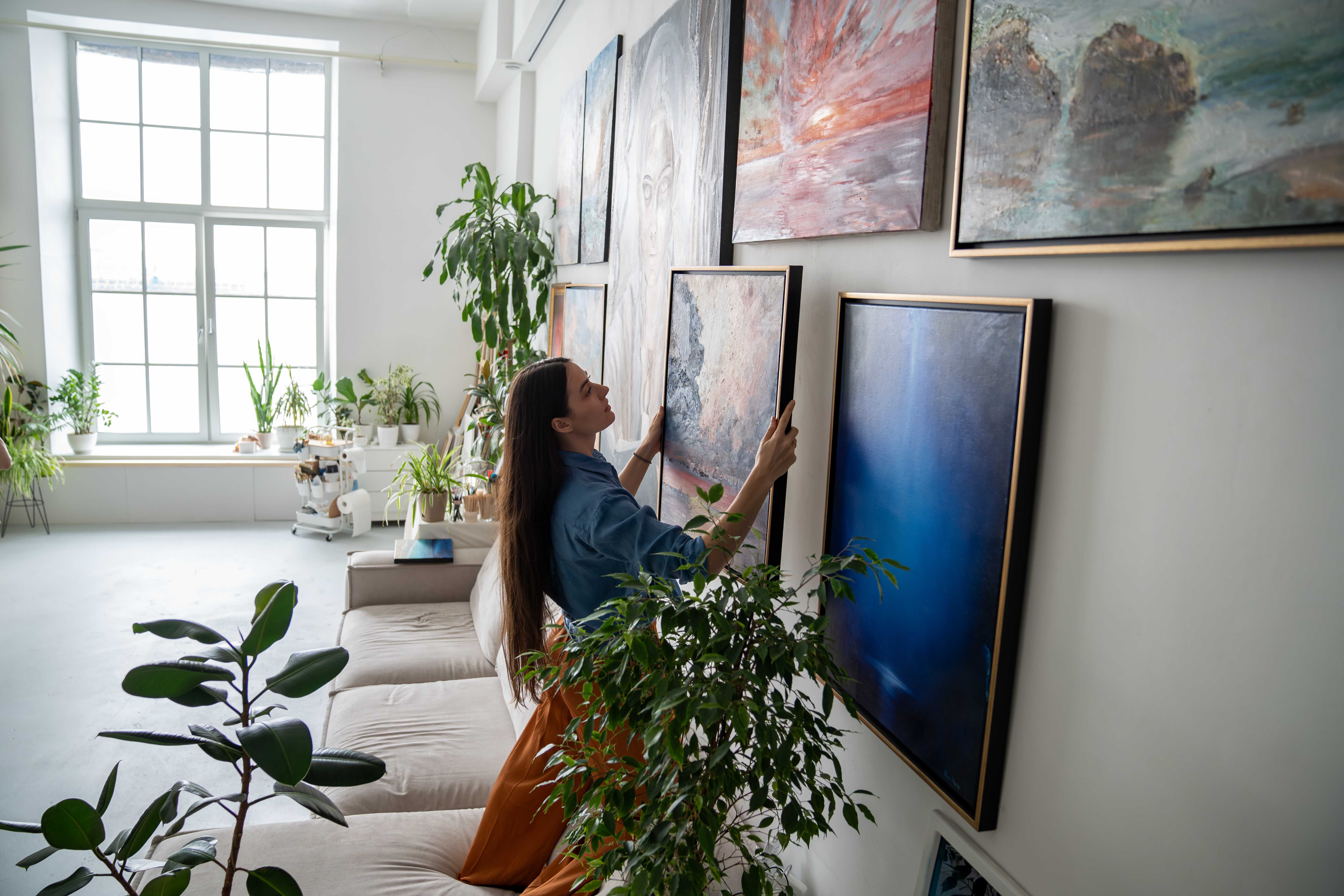woman making gallery wall in home