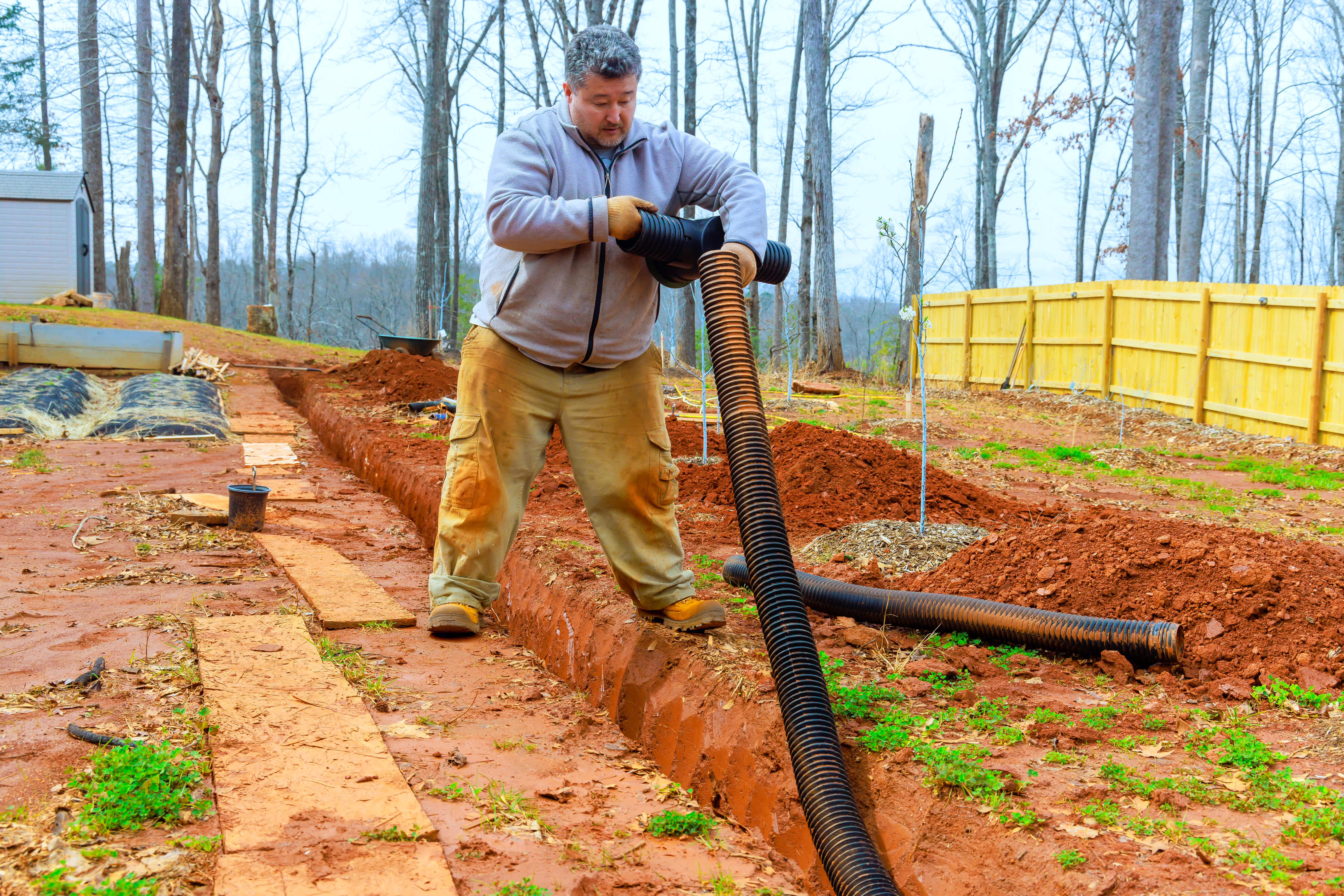 man installing drainage system