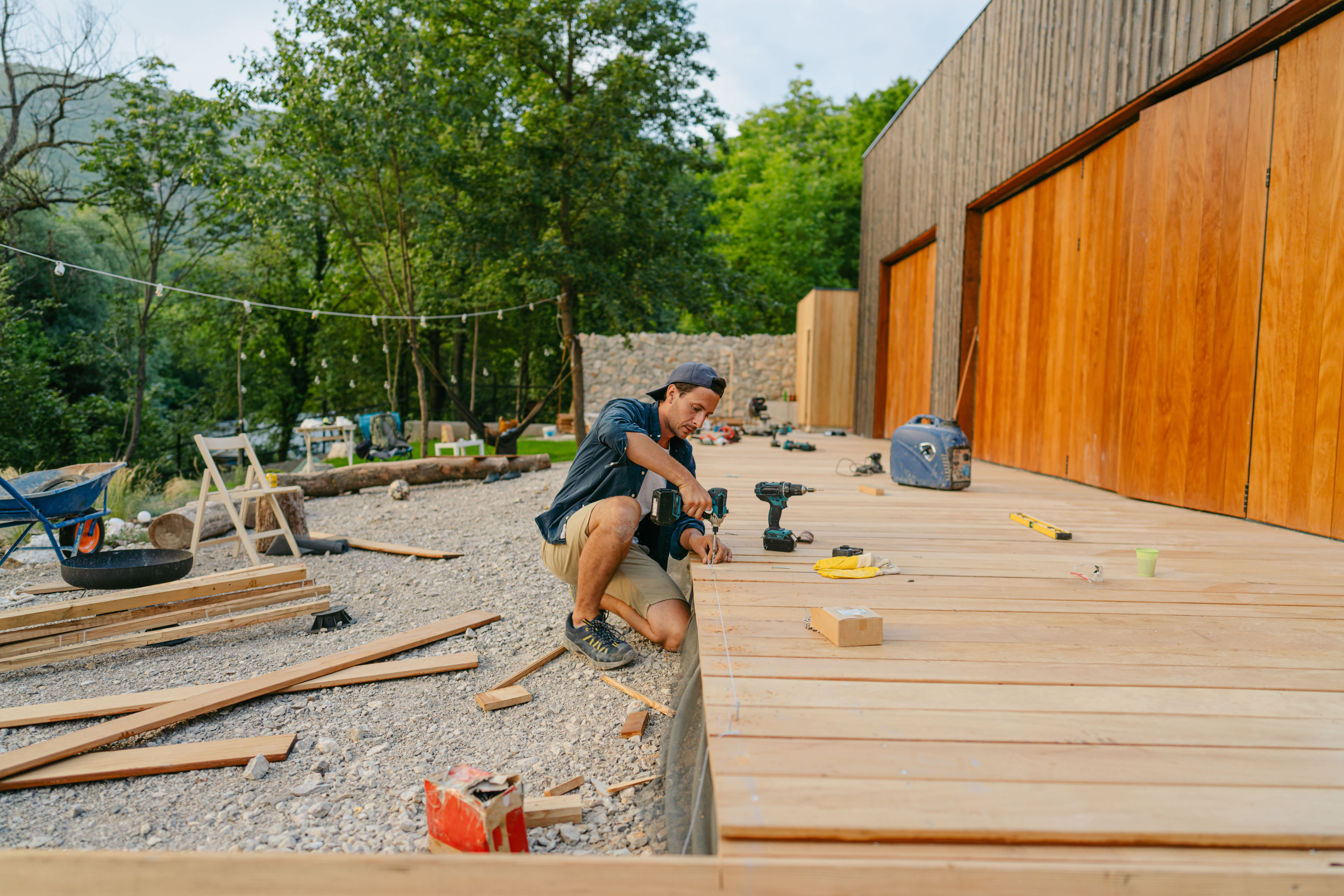 Worker on his knees building wooden deck