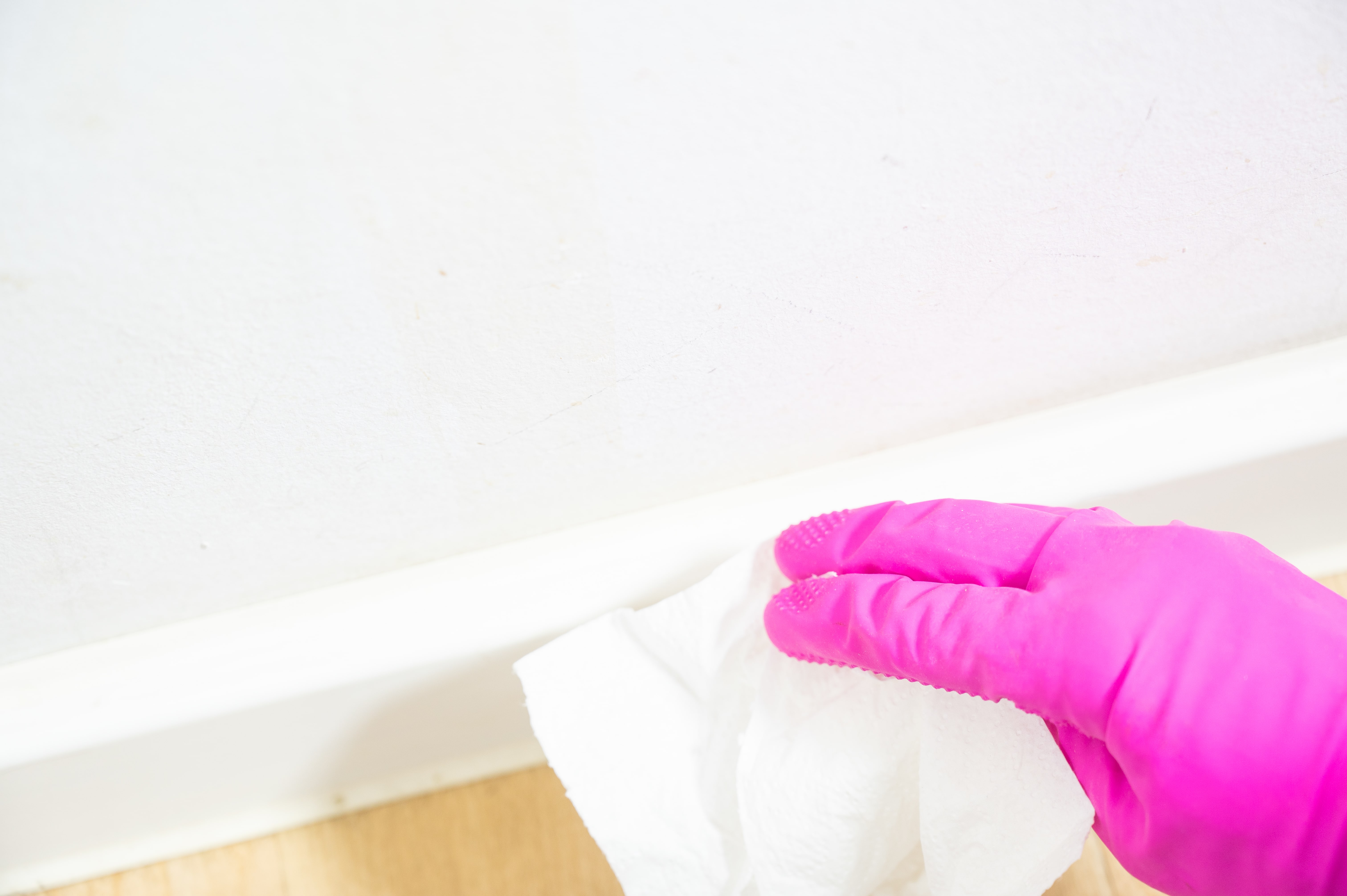 Close-up of cleaning a caulk line of a baseboard