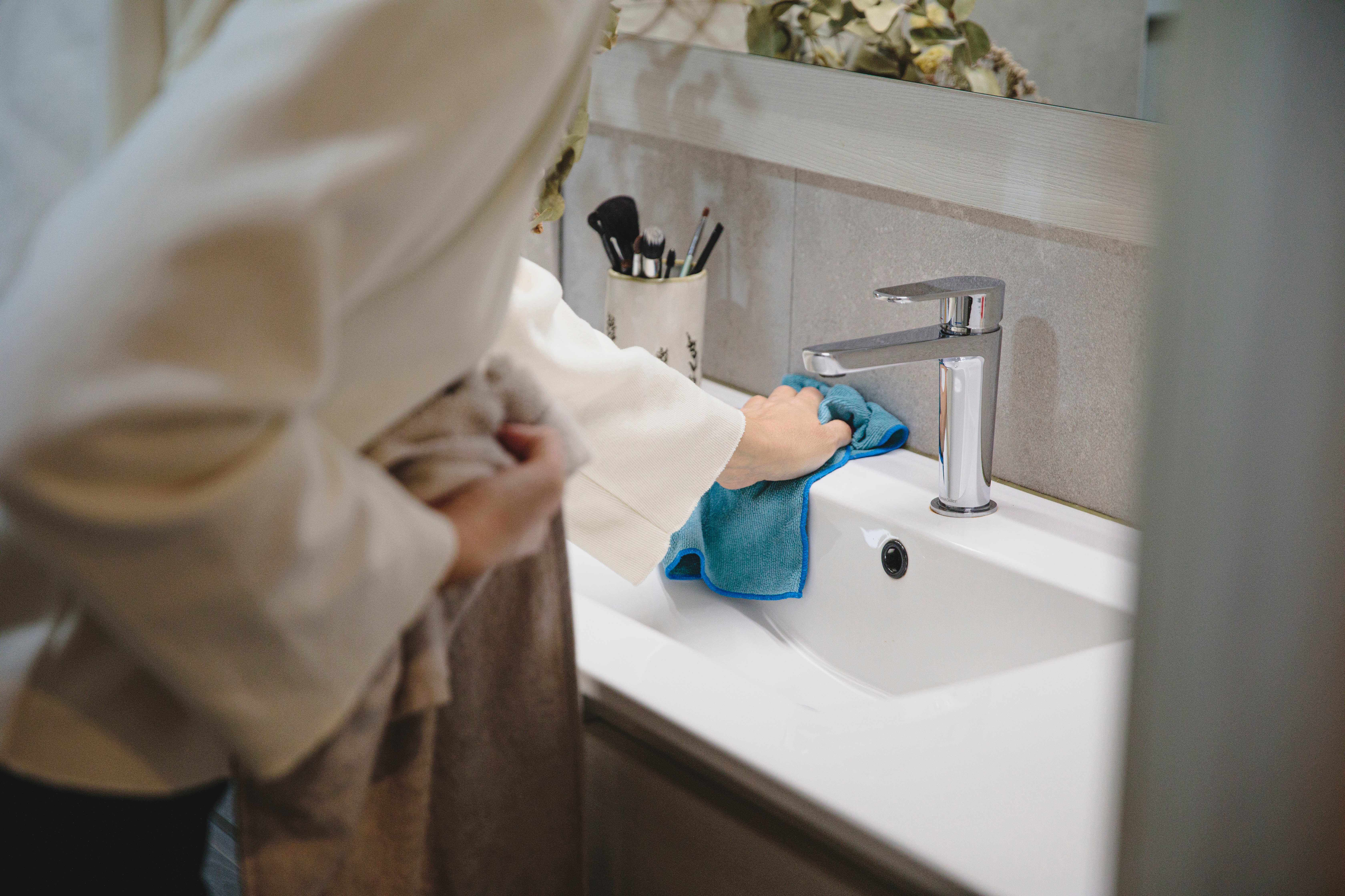 Woman cleaning bathroom sink