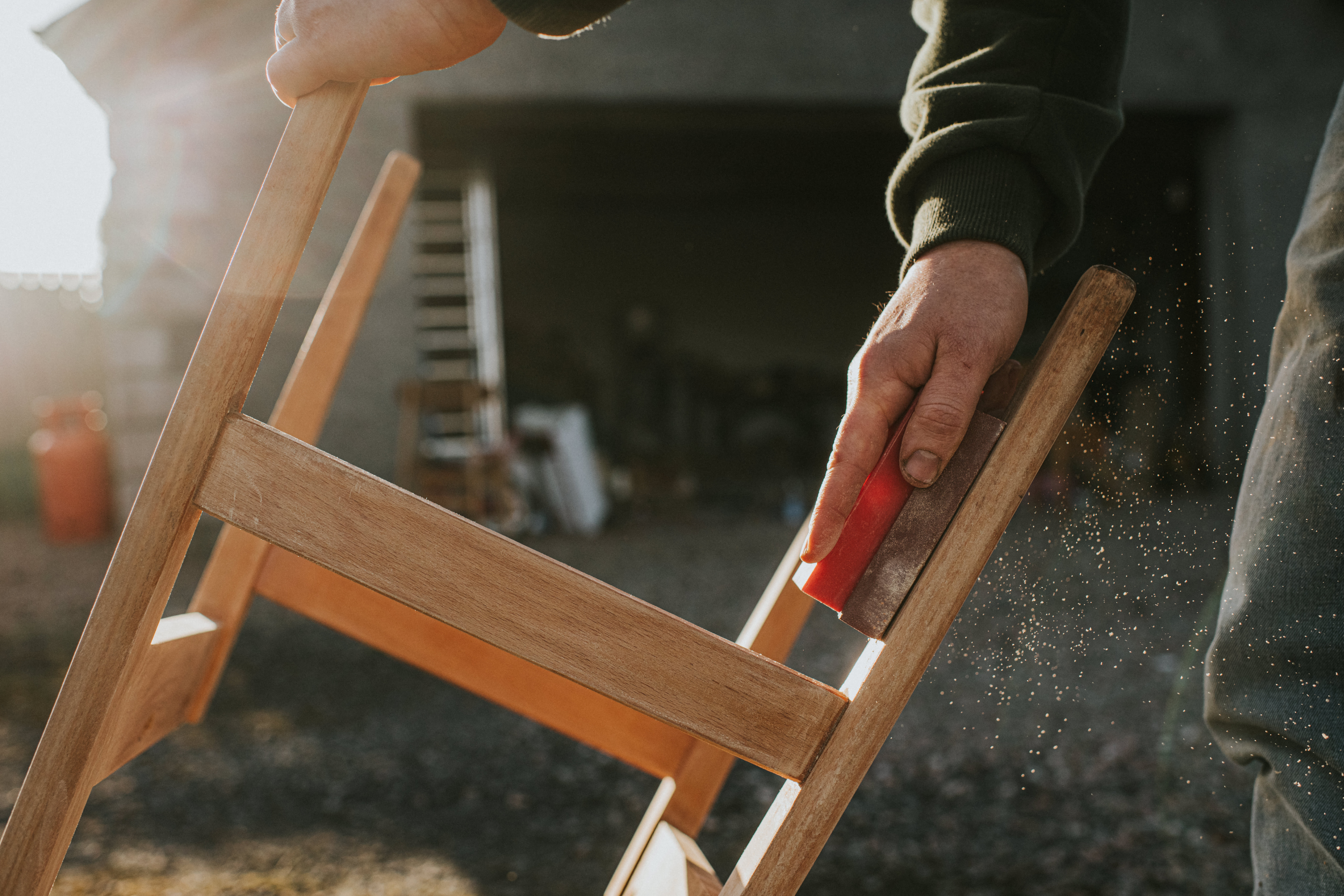 A person sanding a chair