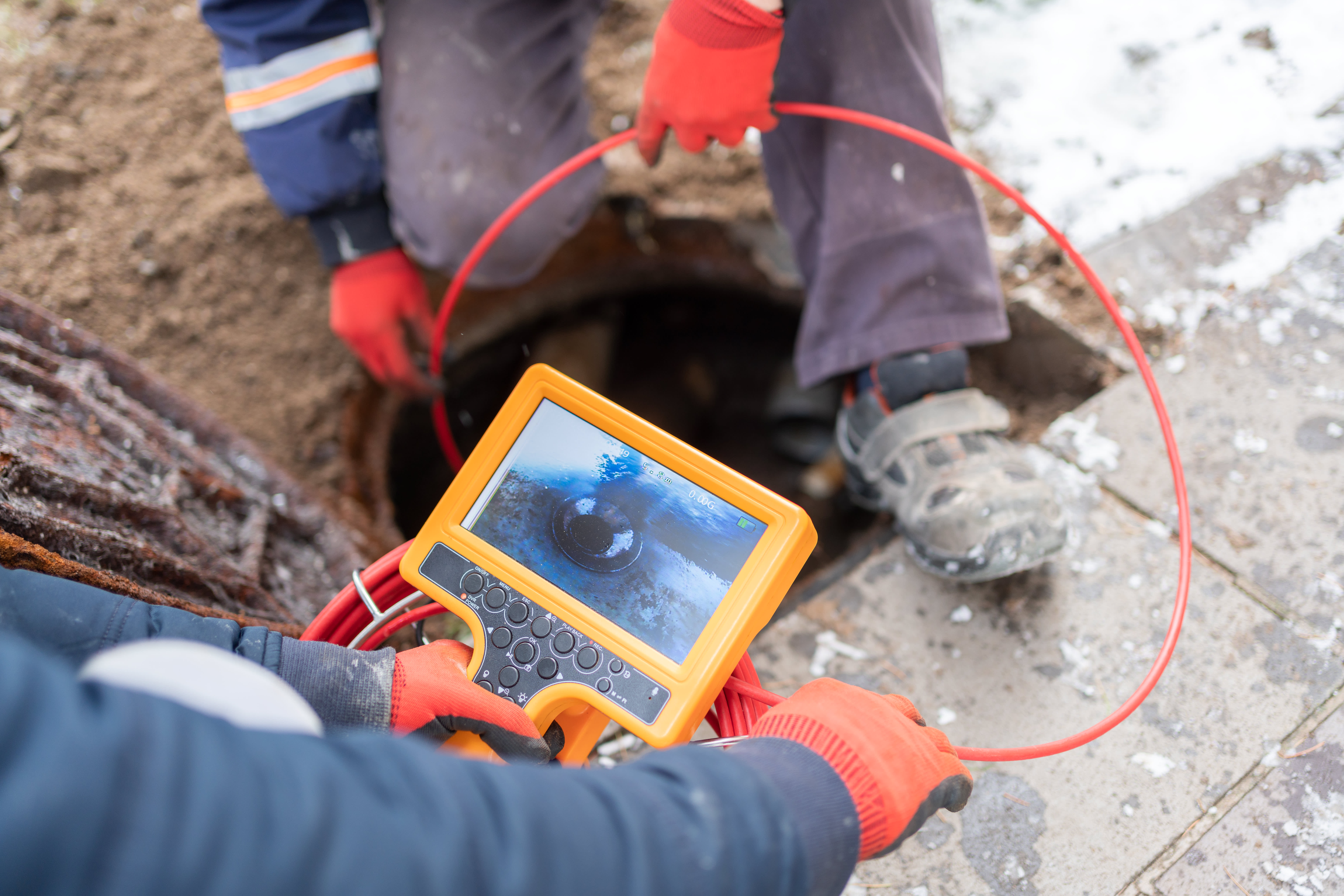 Professionals inspecting a sewer with a camera