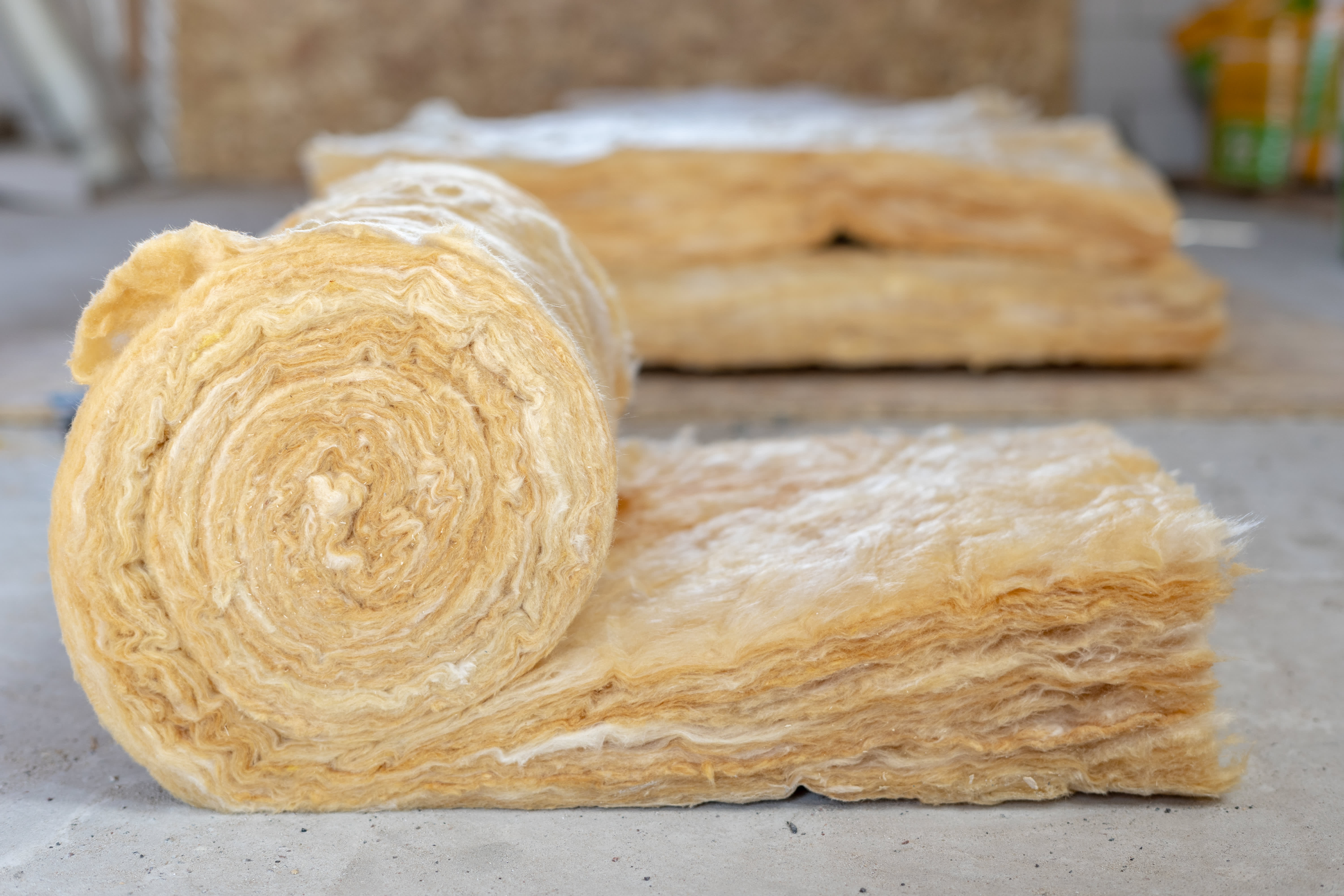 Roll with mineral rockwool lying on attic floor