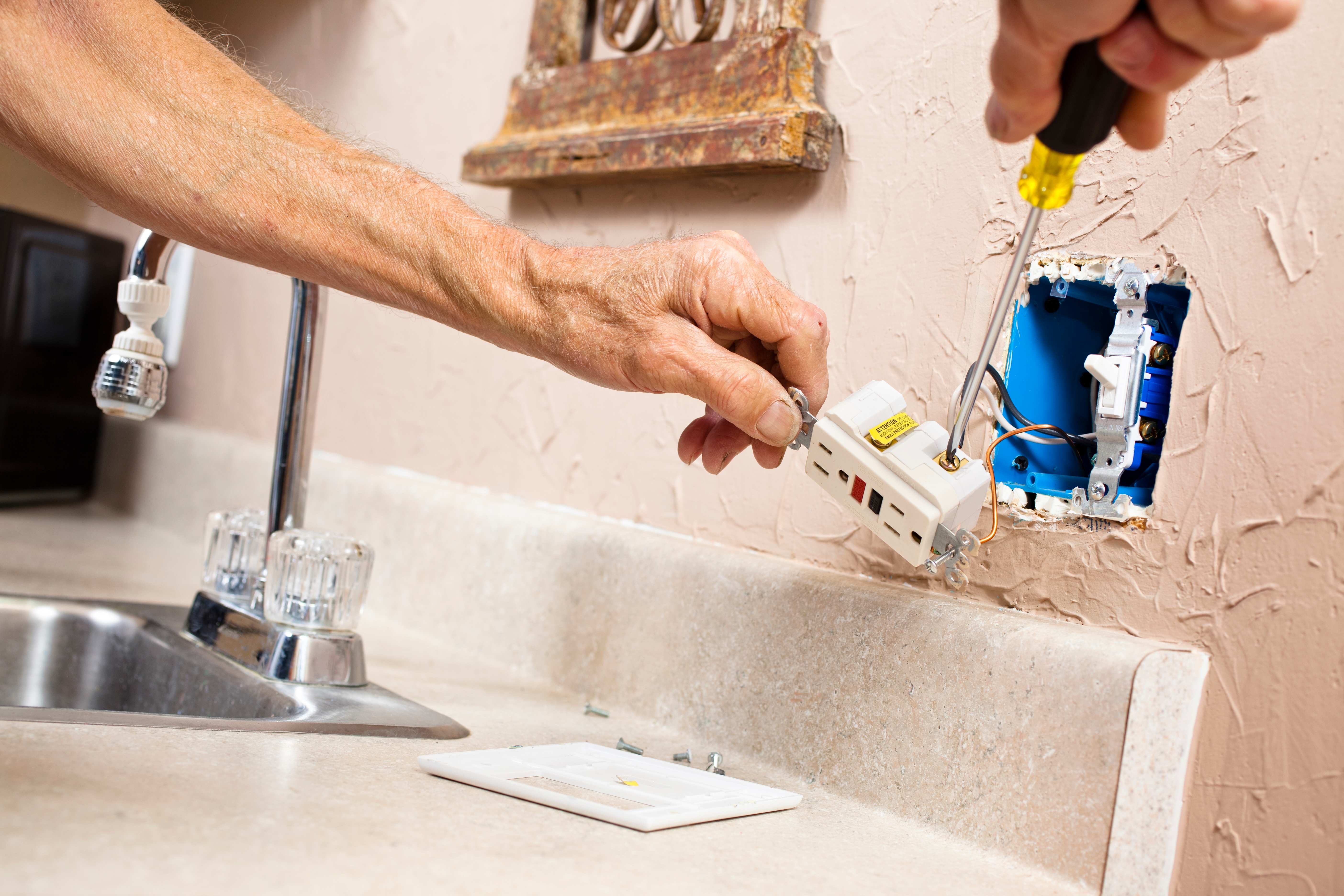 An electrician installing a GFI