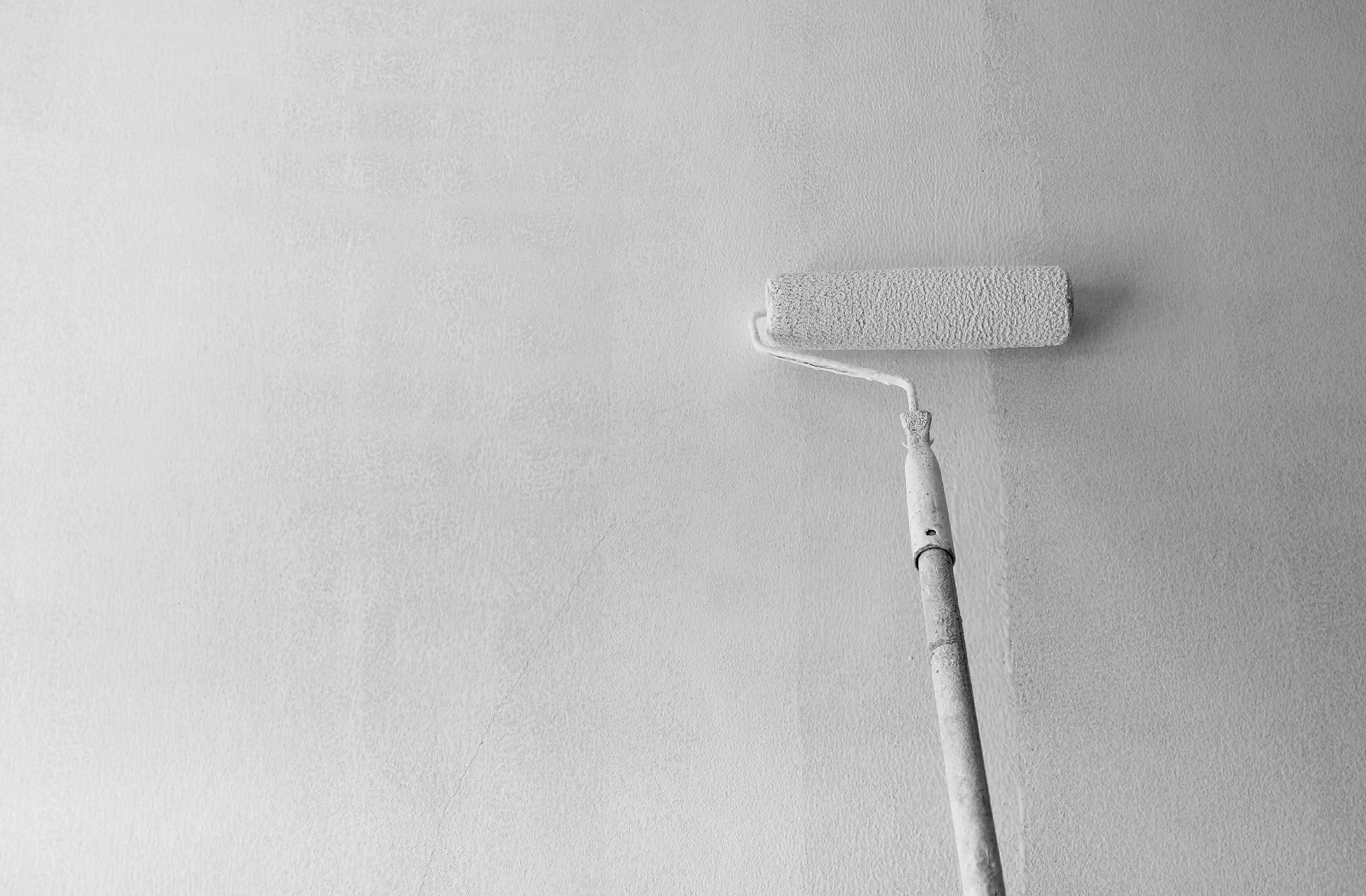 A painting roller applying primer on cement wall