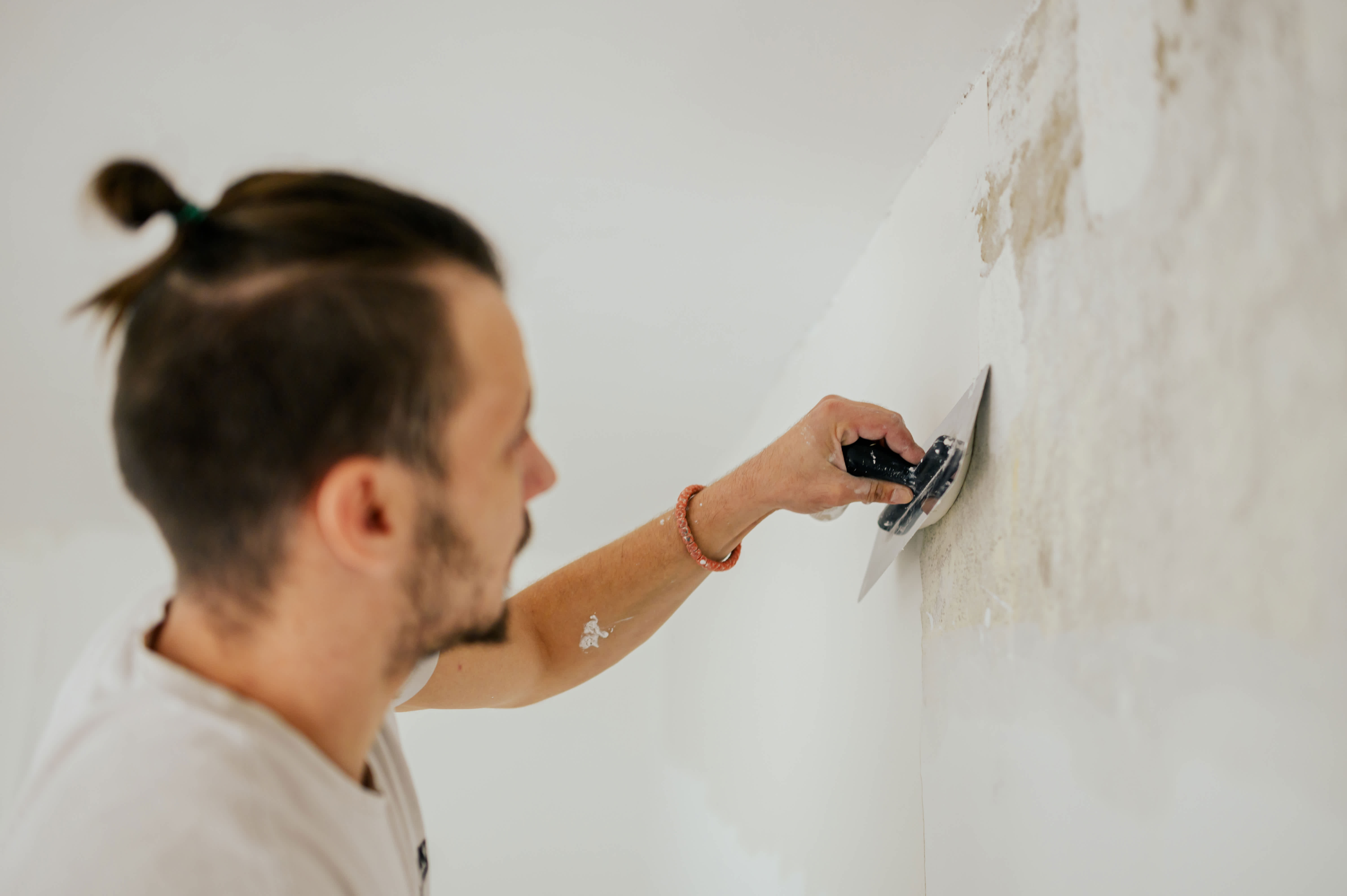 A man applying skim coat with a trowel