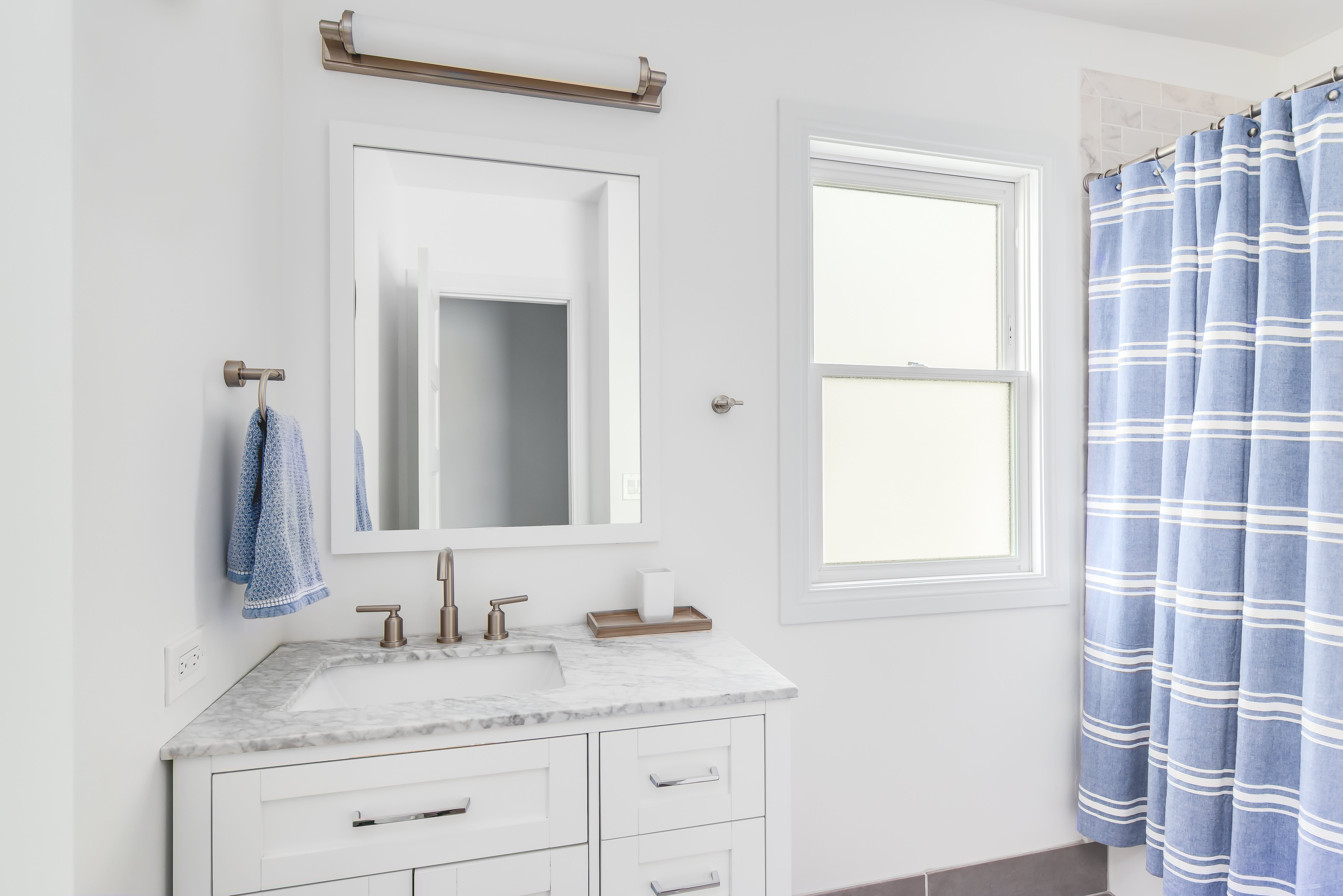 A white bathroom with a blue shower curtain
