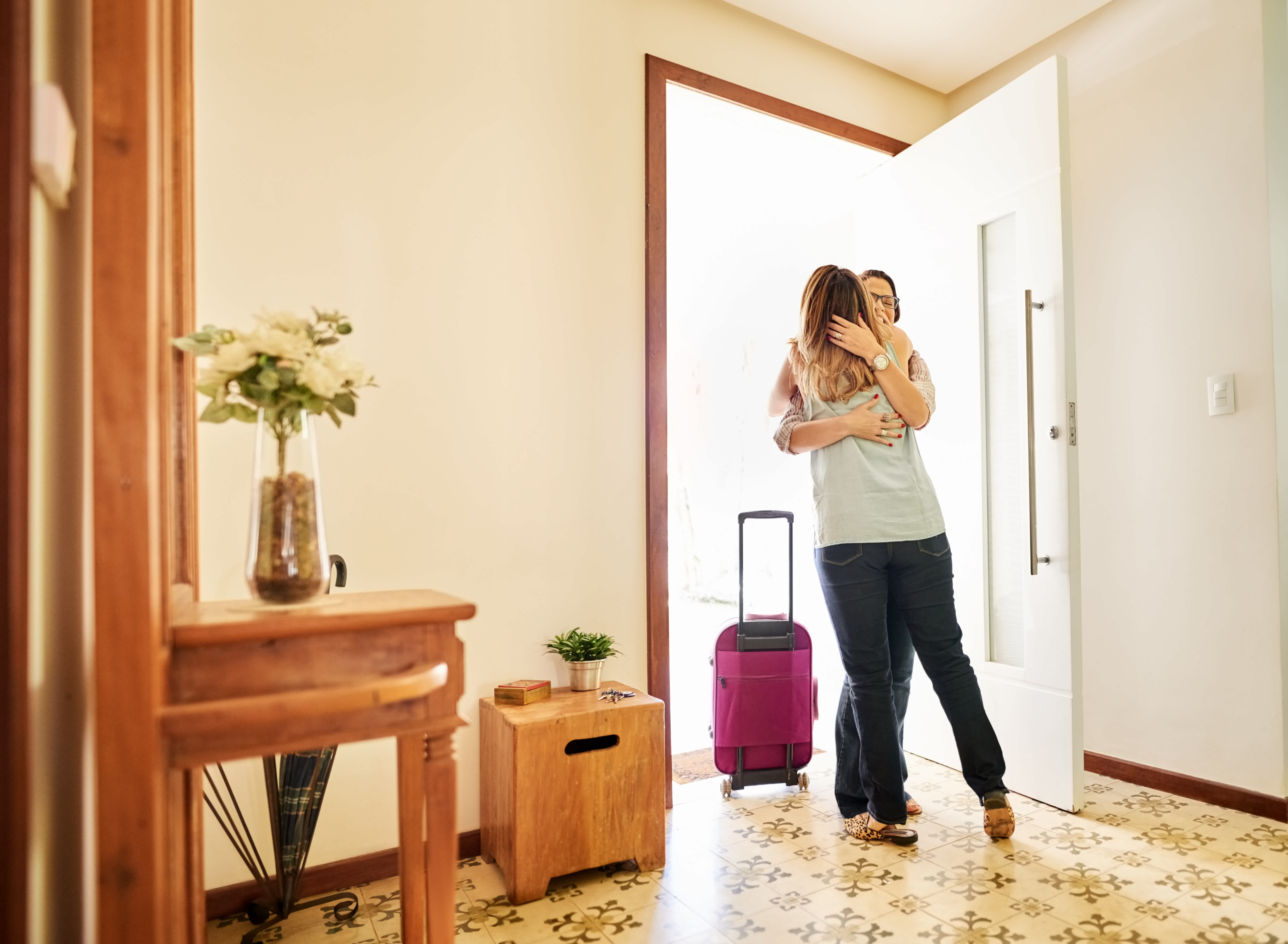Woman greeting and welcoming a friend to her home