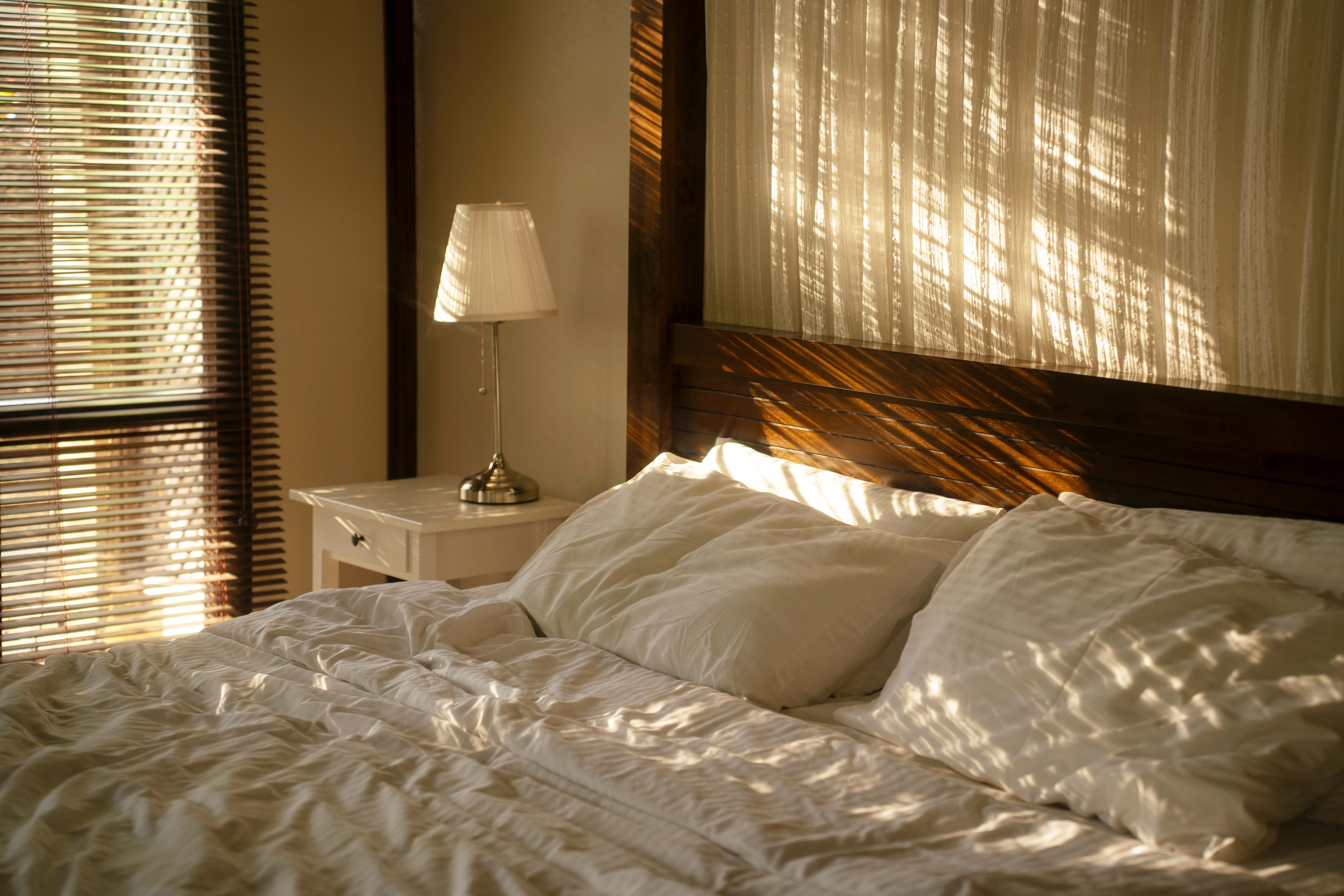 Big wooden bed with white linen
