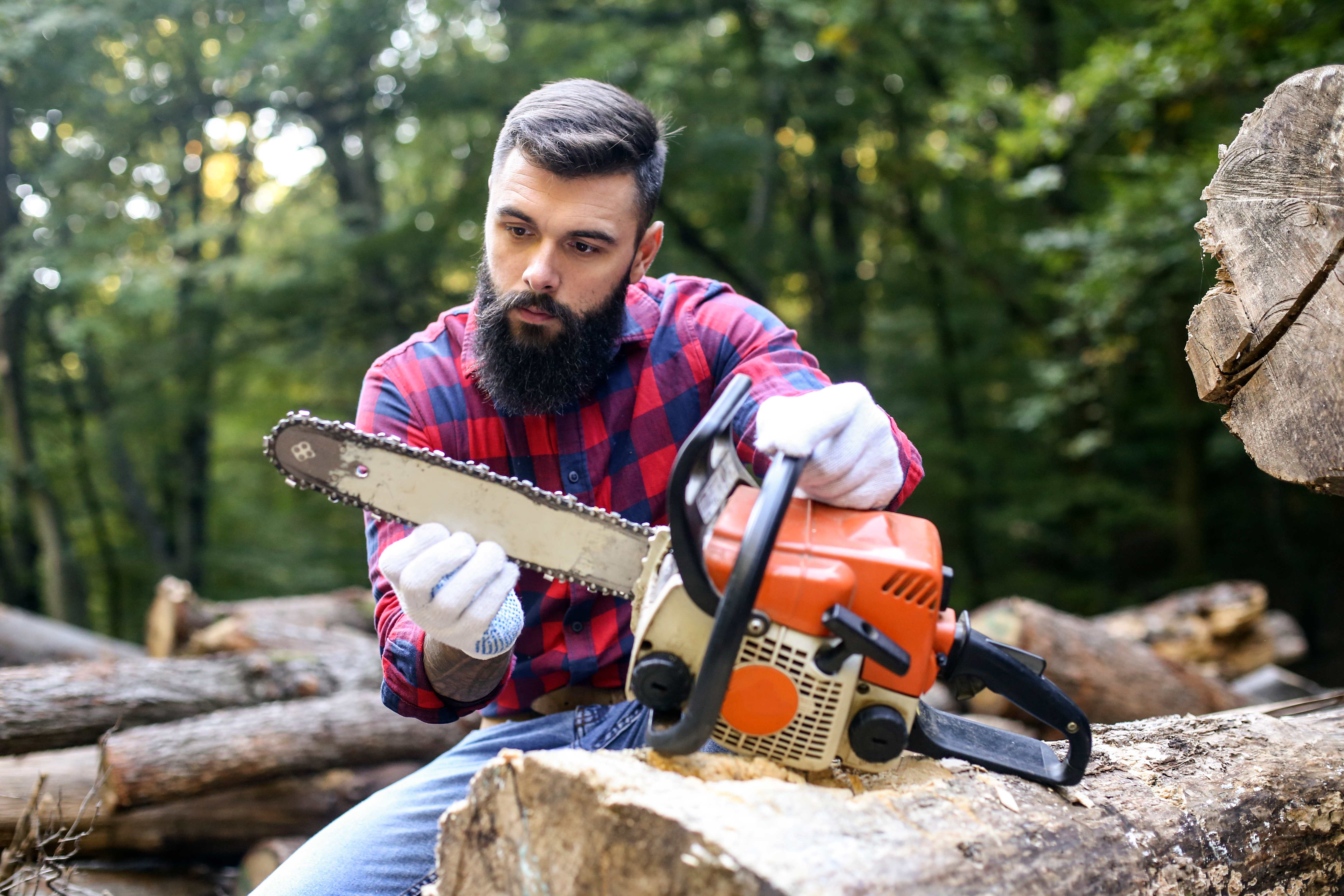 A man inspecting a chainsaw