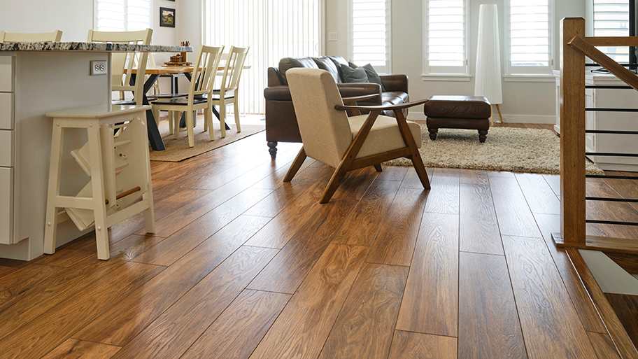Open living-dining area with engineered hardwood floating floor, leather sofa, armchair, and dining table