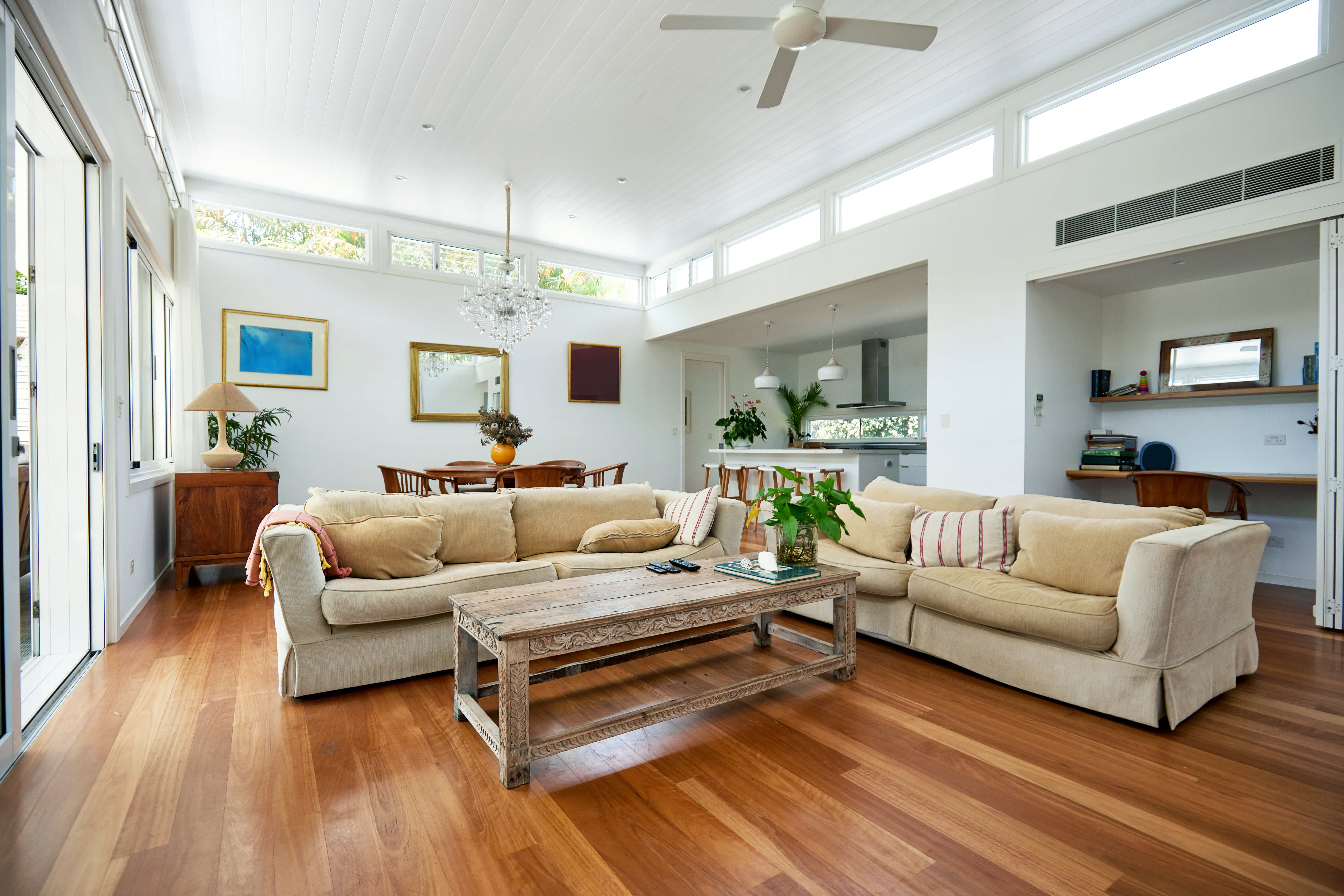 Open plan modern one-story interior with floating floors in living area, dining, and kitchen