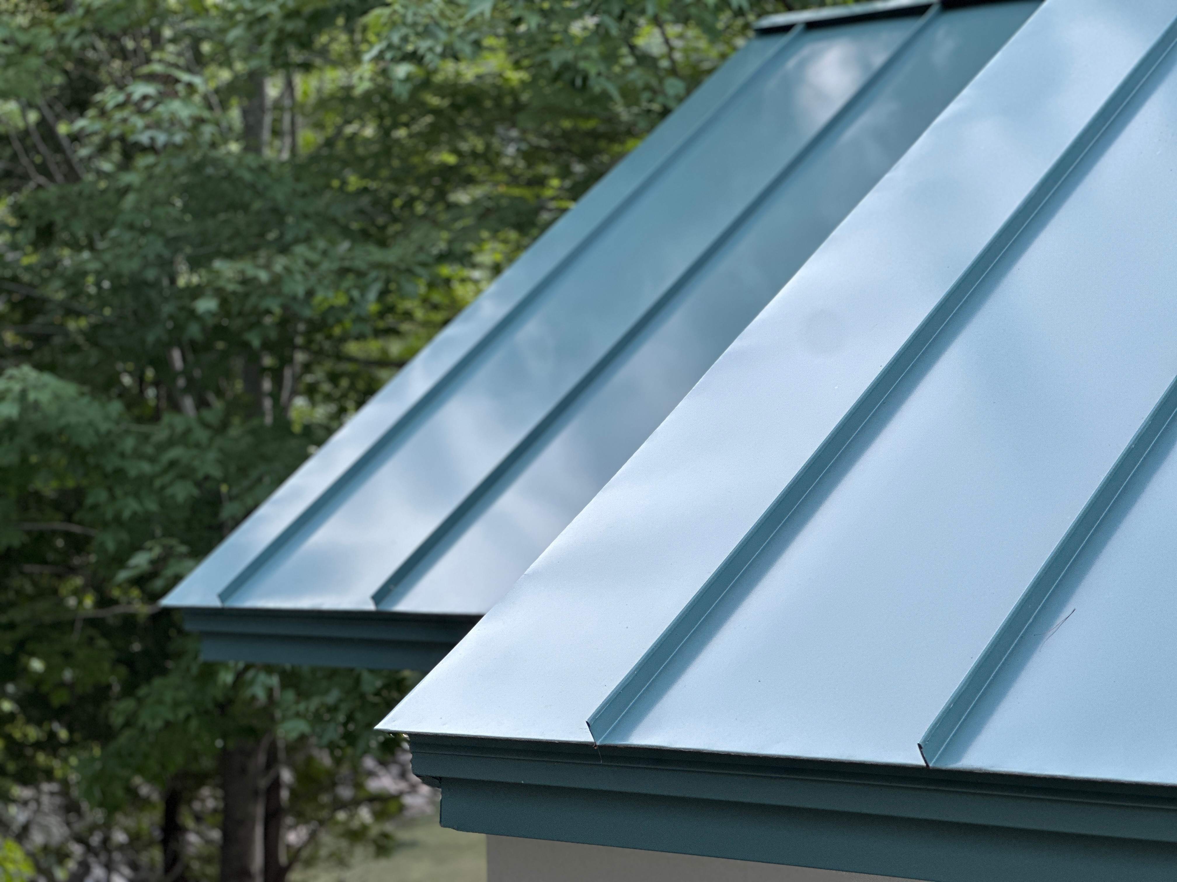 Close-up view of a blue standing seam metal roof with raised seams