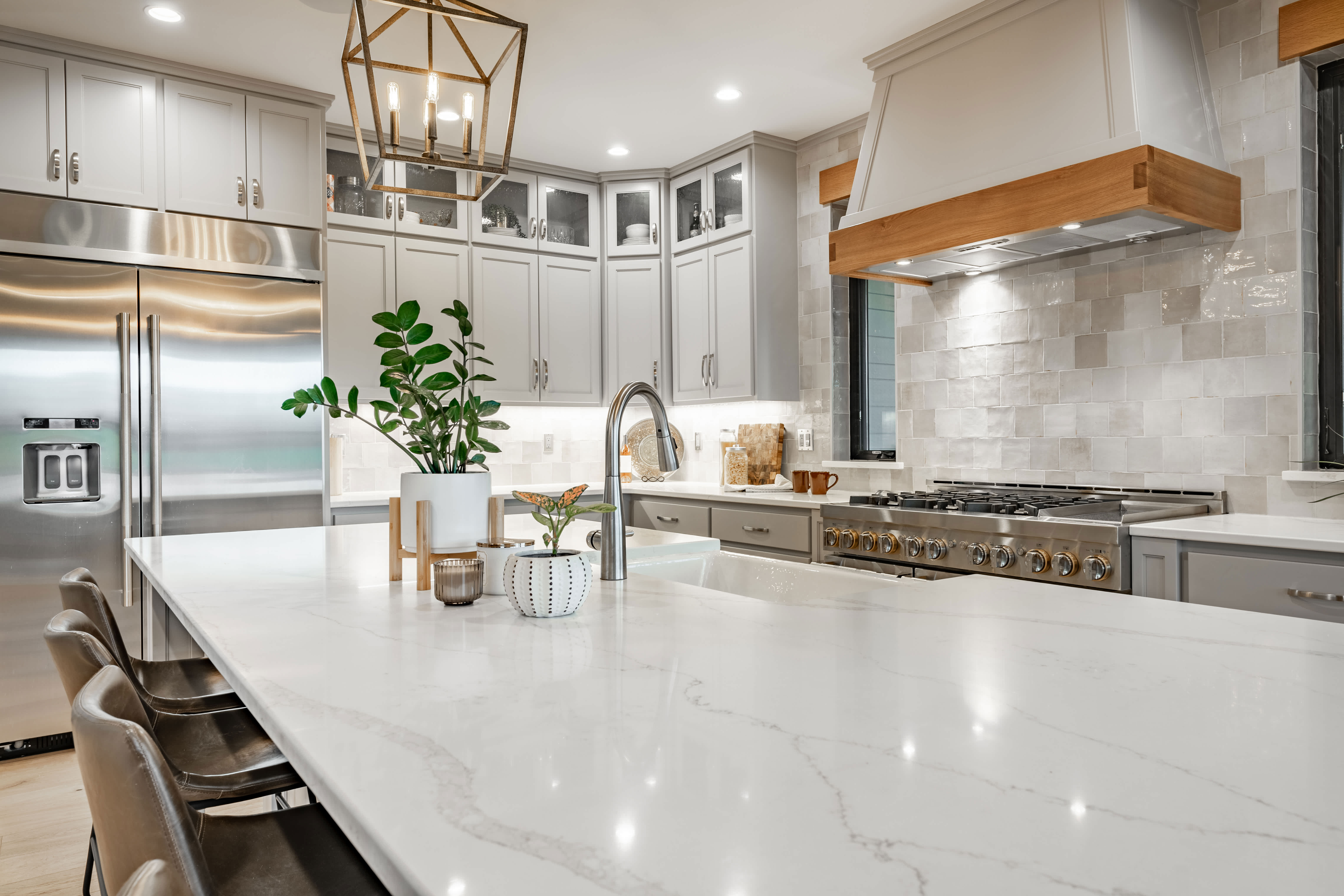Bright modern kitchen with quartz countertops, stainless steel appliances, and white cabinetry