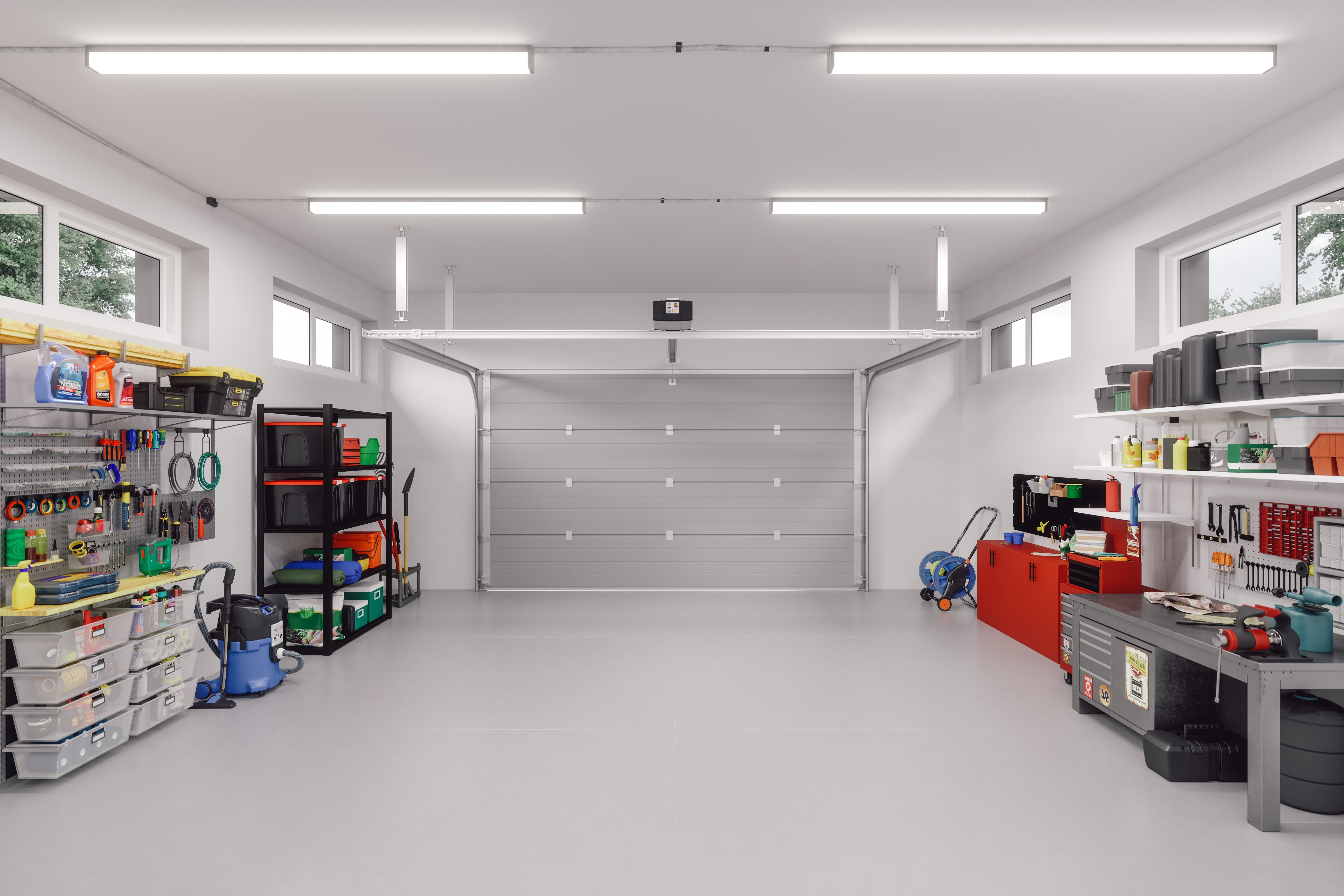Spacious two-car garage with neatly organized shelves, workbenches, storage bins, and tools arranged along the walls