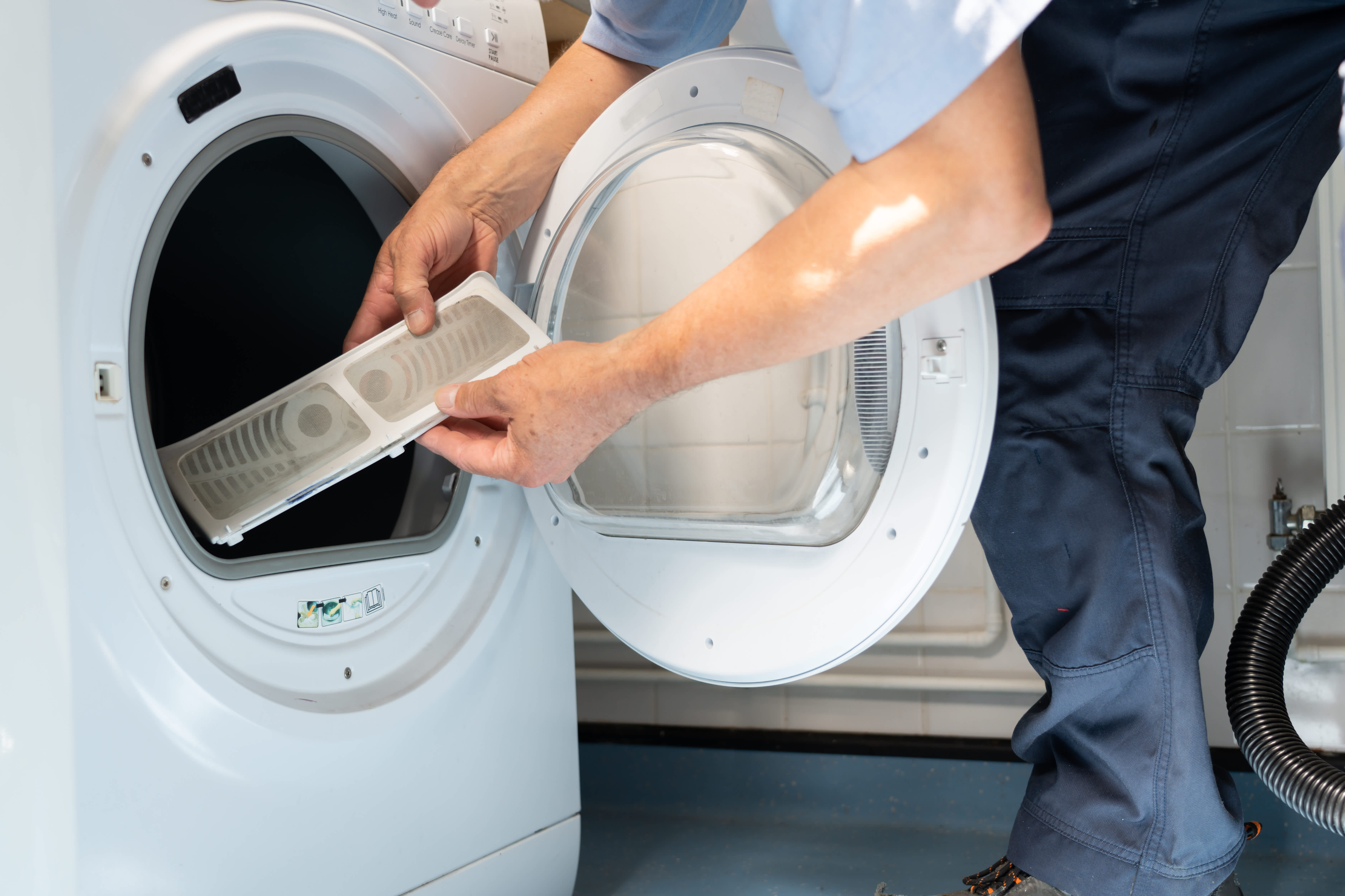 Engineer is repairing a tumble dryer