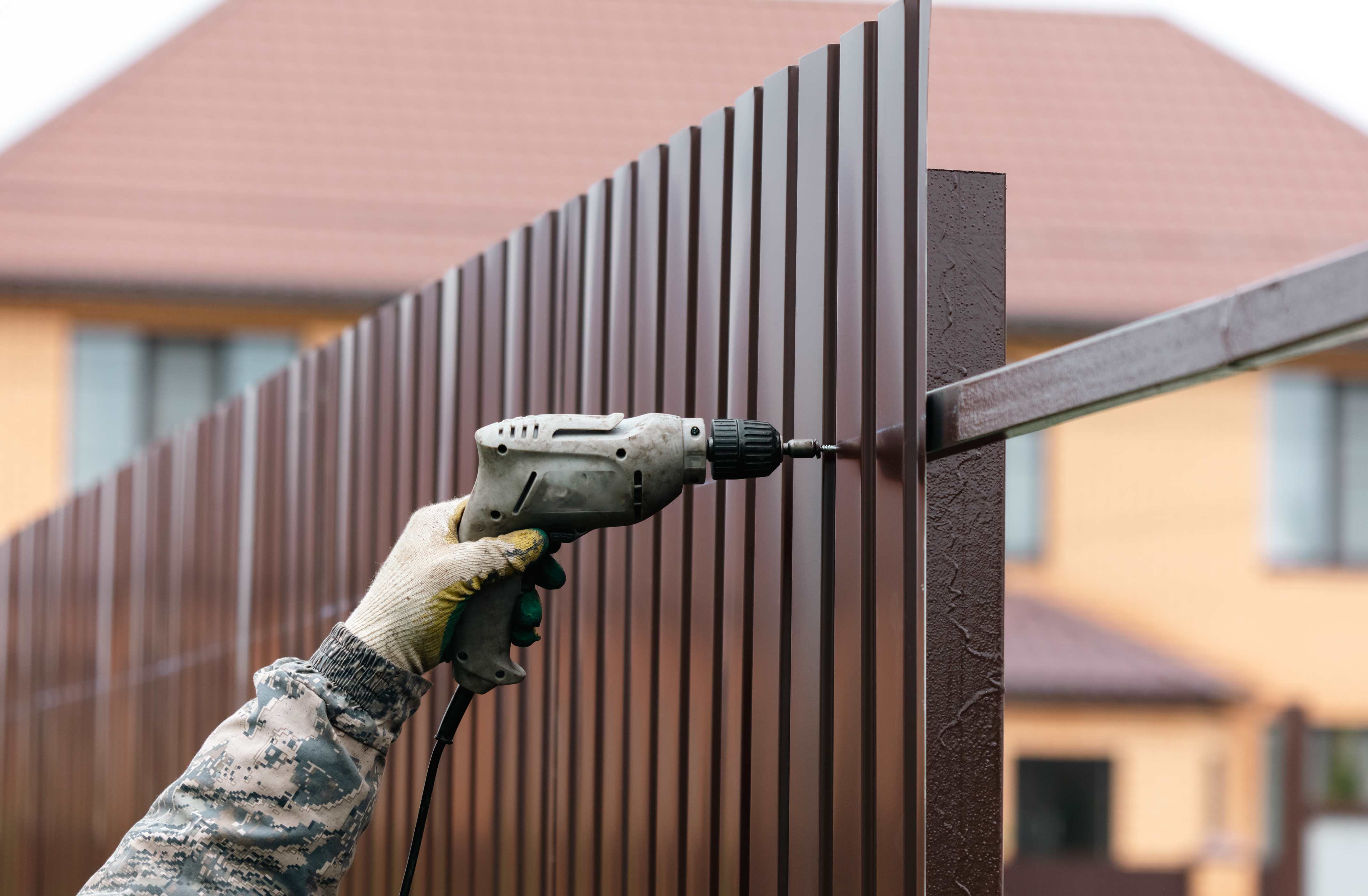 Worker installing metal fence