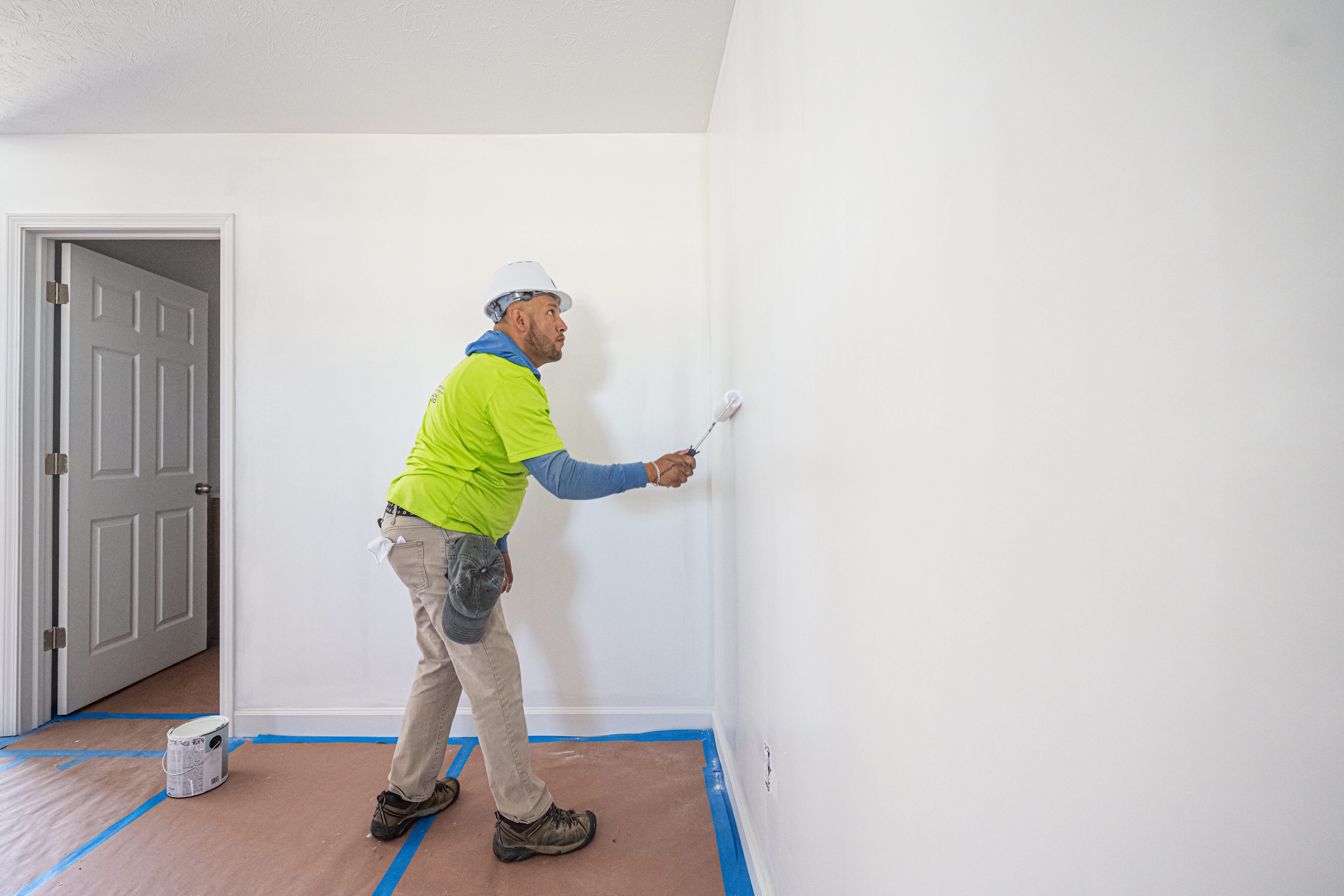 Worker paints a wall in a newly remodeled house
