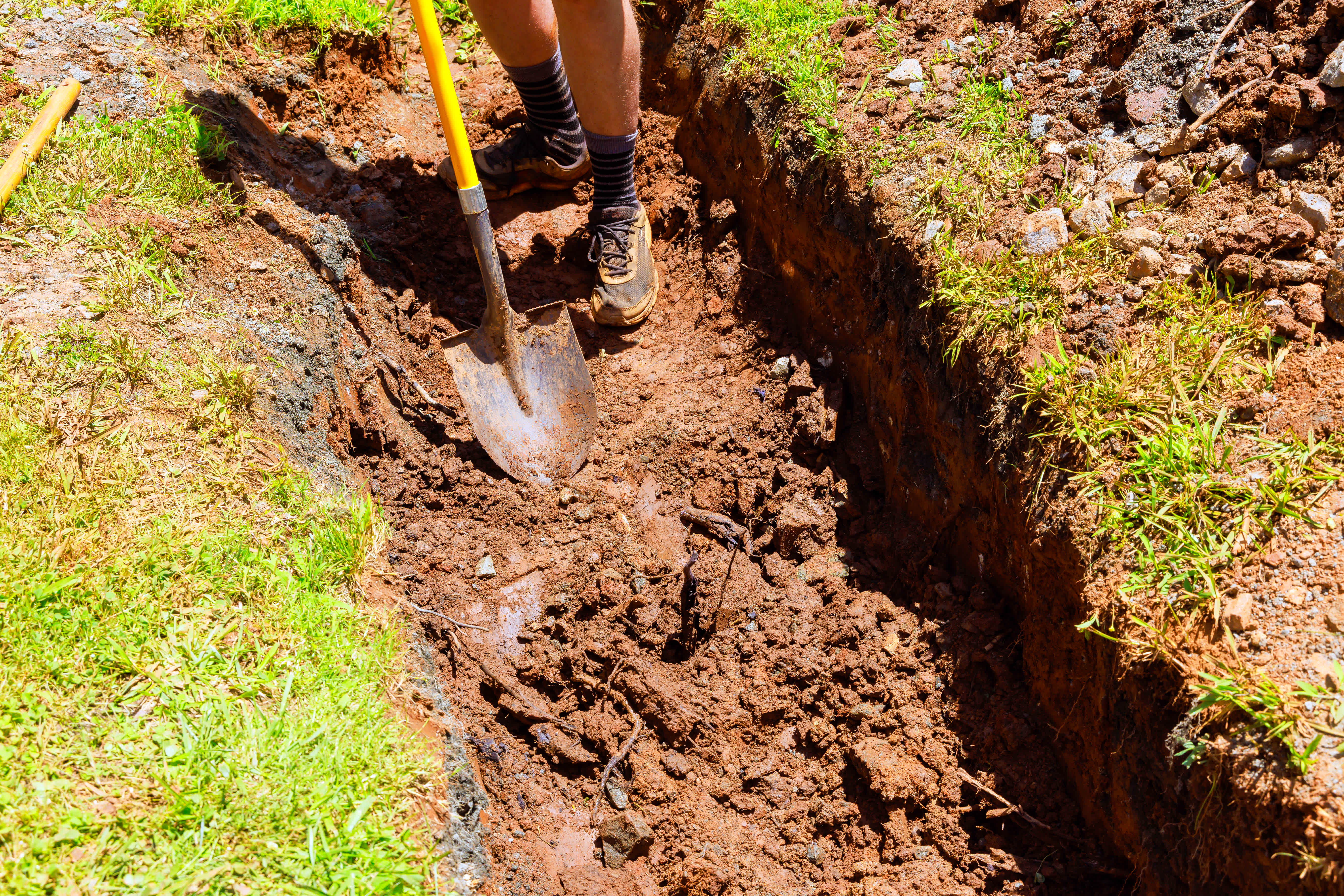 A professional digging a trench