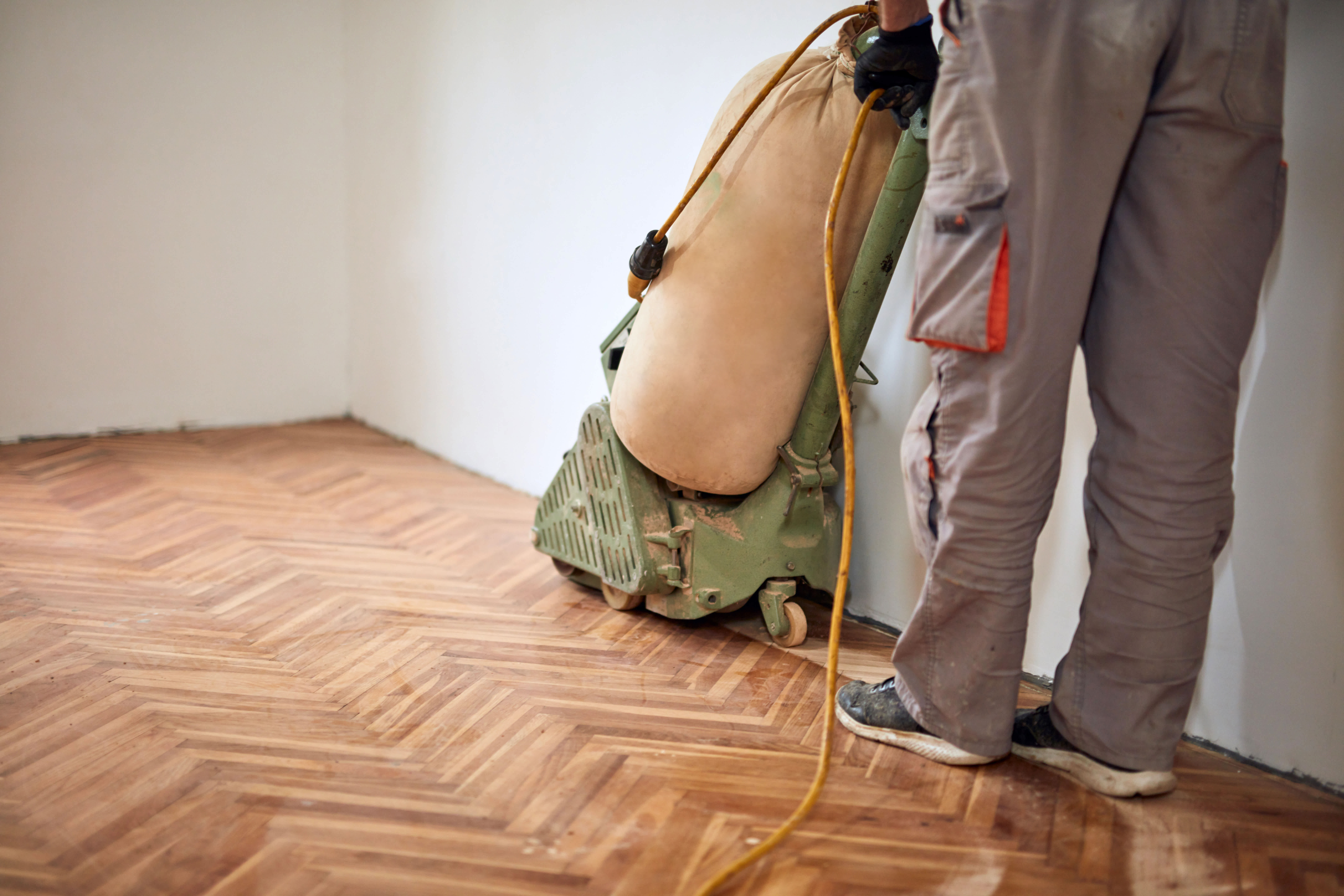 A professional sanding a wooden floor