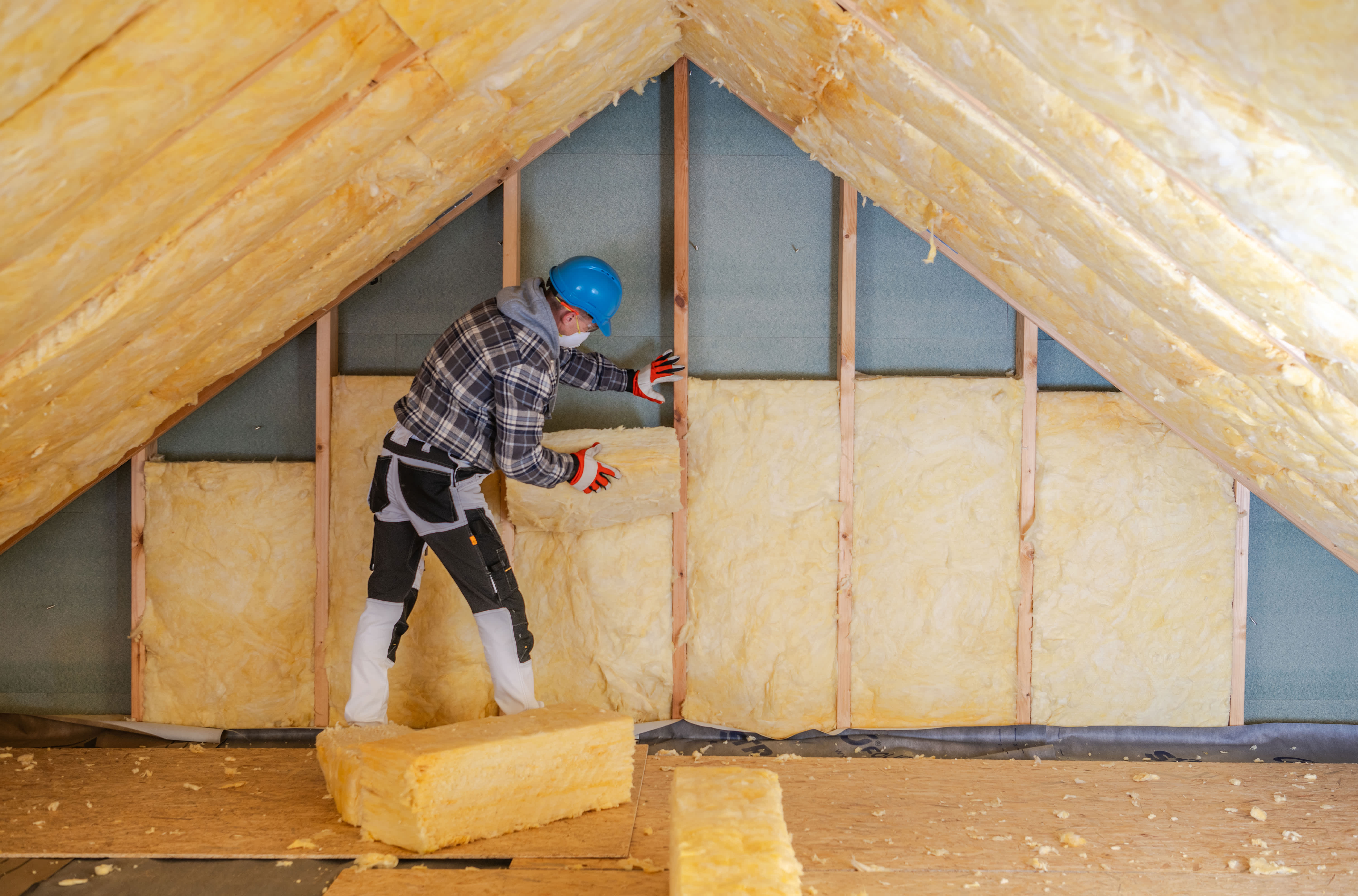 A professional insulating a house’s attic