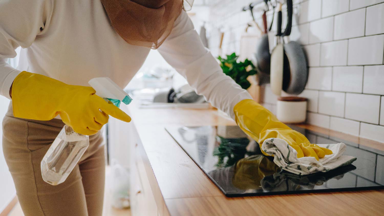 A woman cleaning kitchen surfaces
