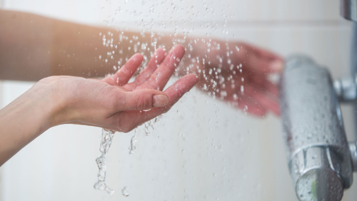 A woman trying running water from the shower
