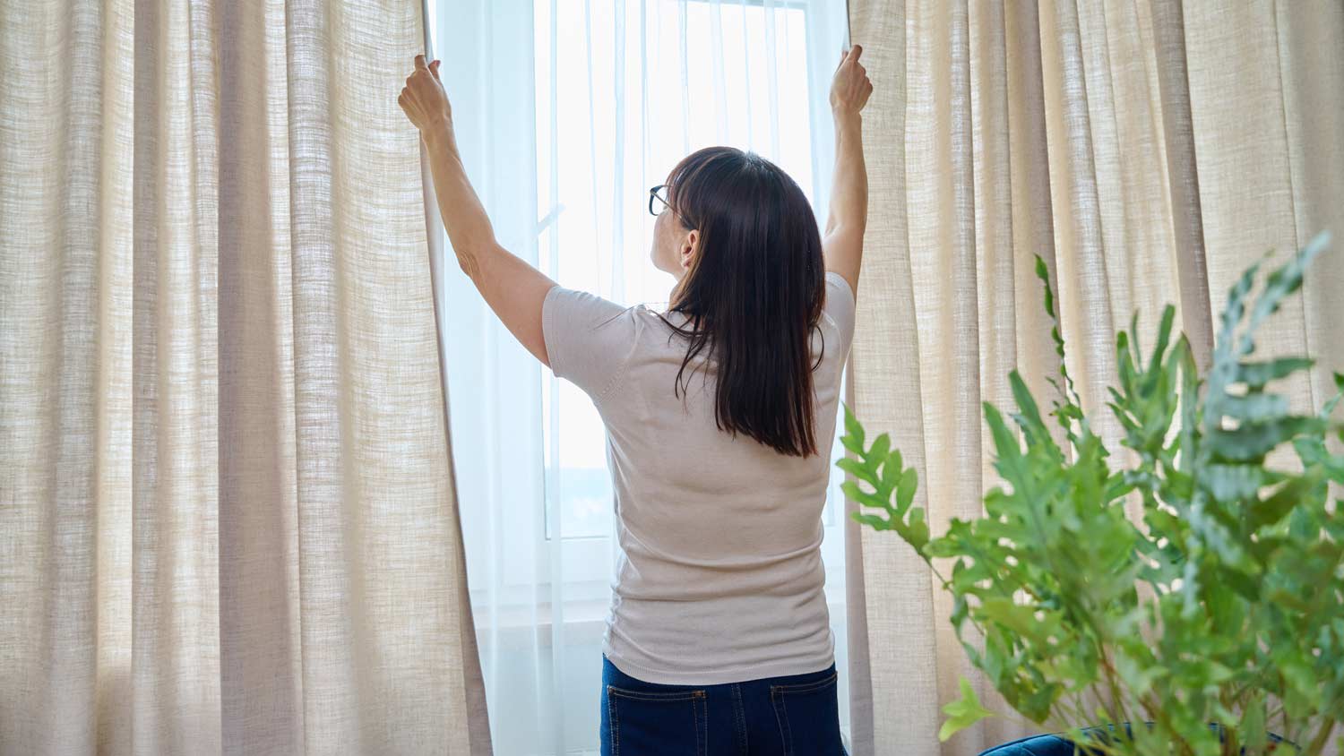 Woman opening curtains